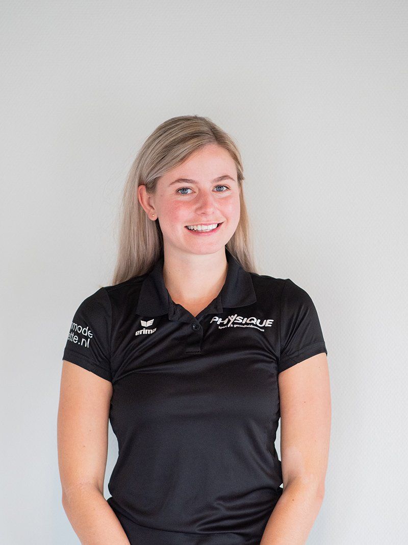 Een vrouw, gekleed in een zwart poloshirt, glimlacht naar de camera.