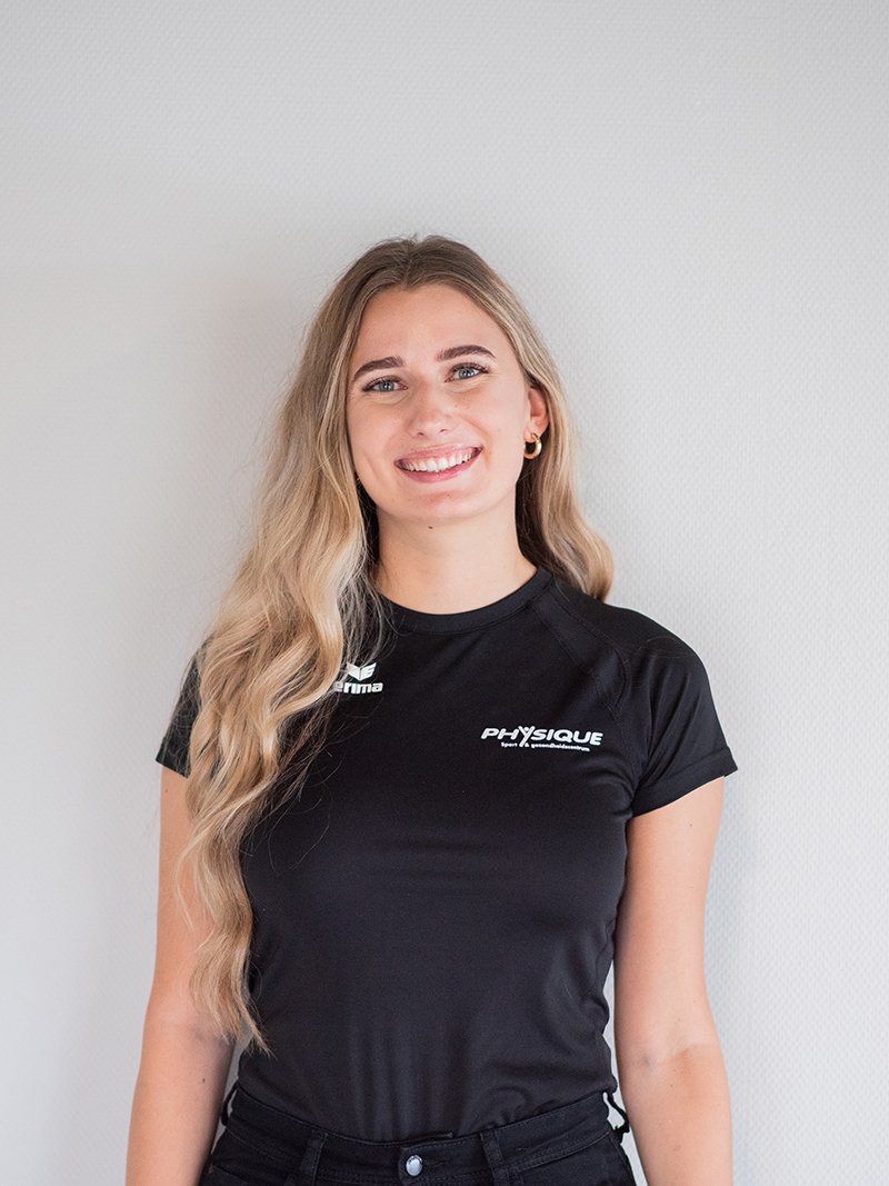 Een vrouw draagt ​​een zwart t-shirt en glimlacht.