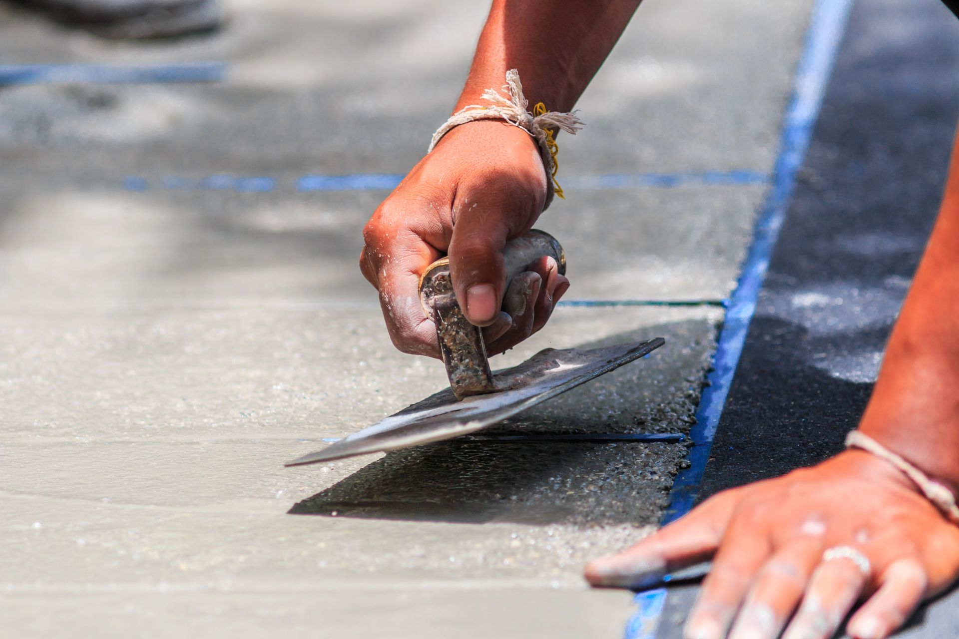 concrete contractor resurfacing a small section of concrete walkway using a trowel