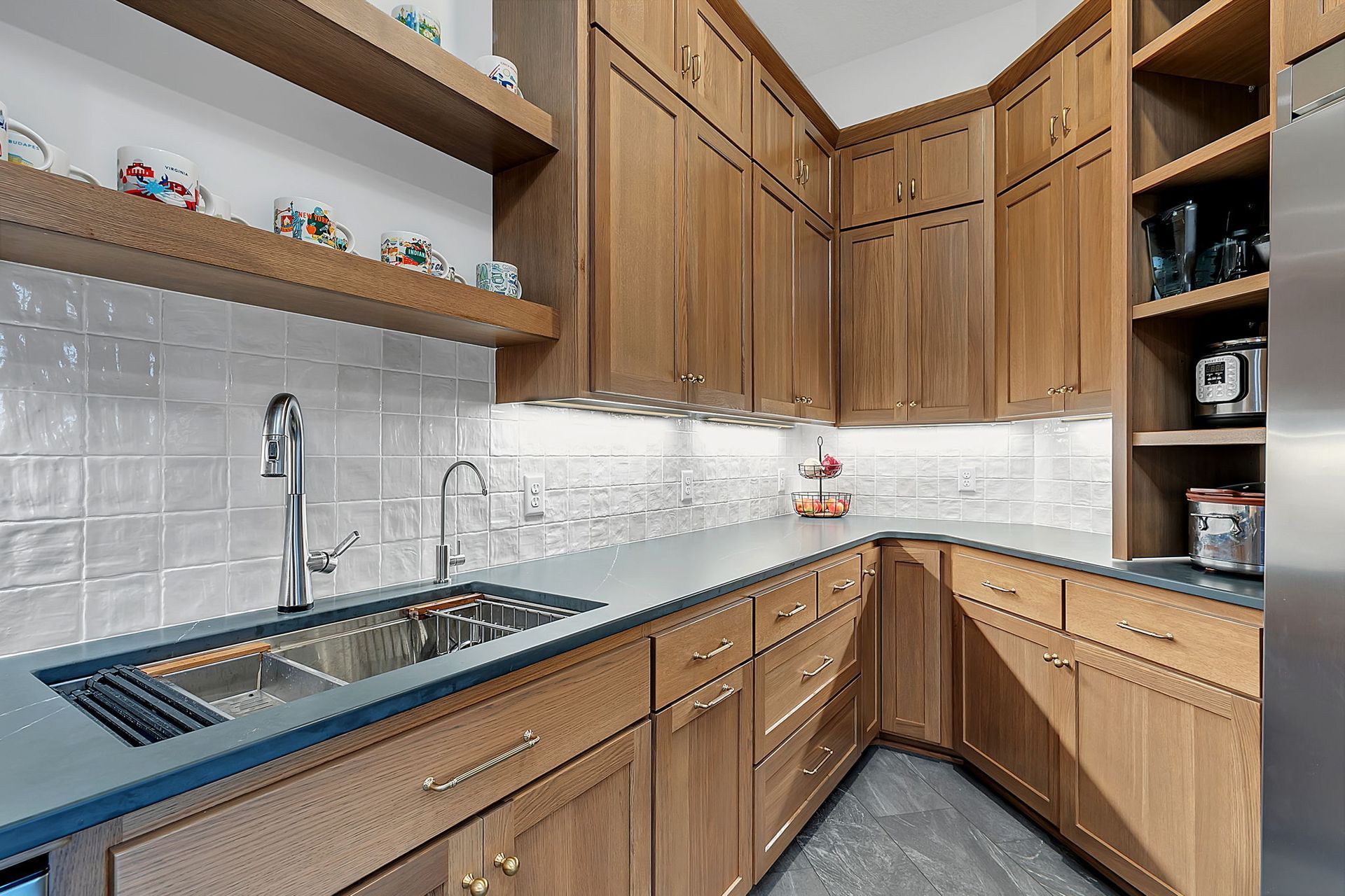 A kitchen pantry with wooden cabinets, a sink, and a countertop.