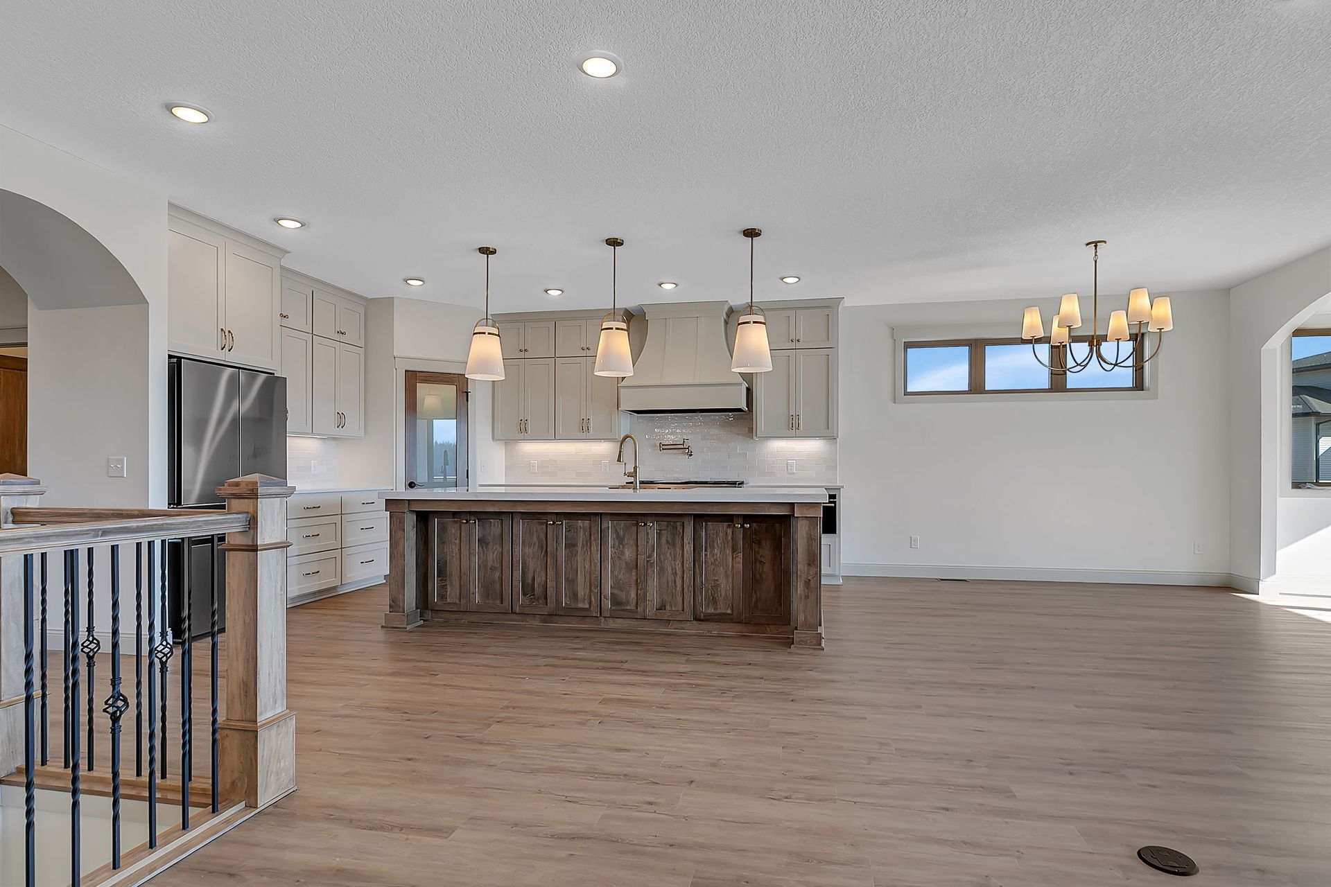 Spacious kitchen with a wooden island, light cabinets, and hardwood floors.