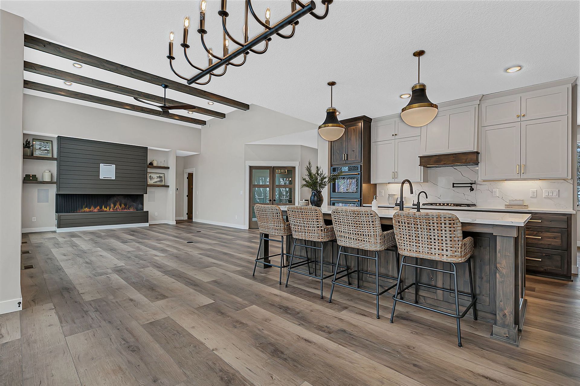 Open-concept kitchen and living room with wooden floors. 