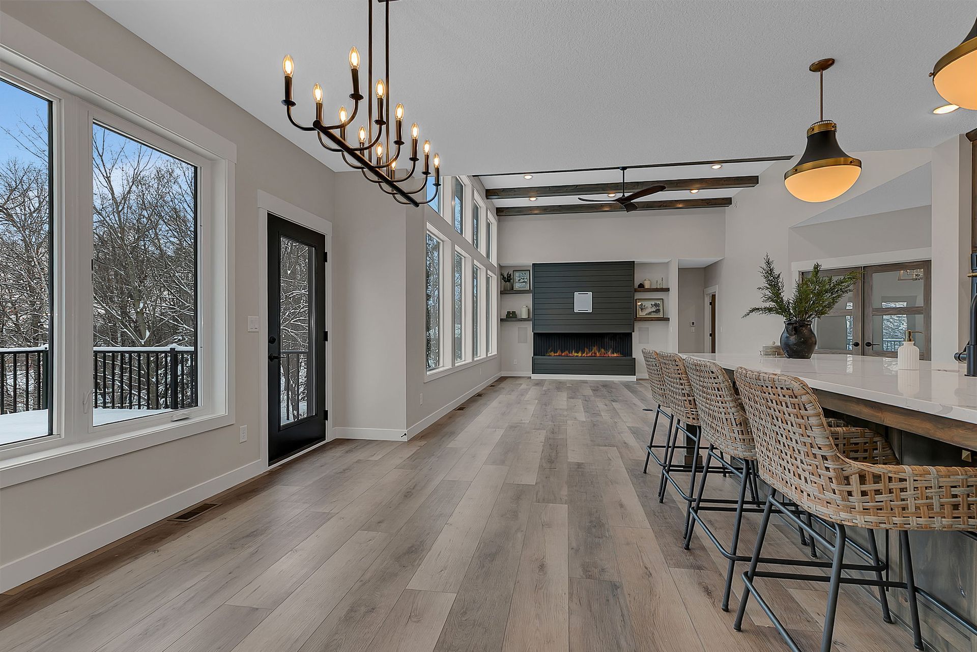 Spacious interior with large windows, fireplace, and bar seating. Light wood floors and neutral walls.