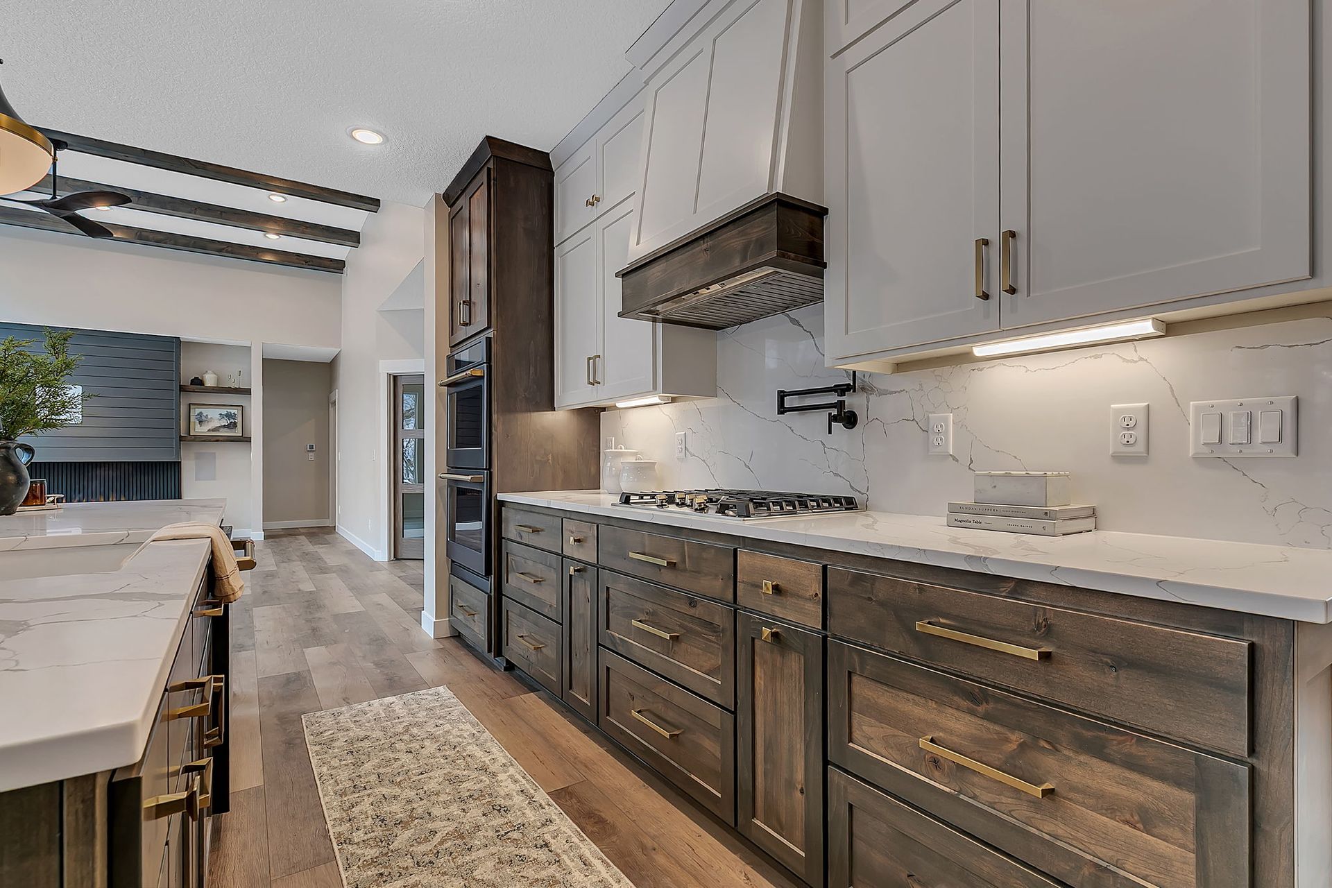 Modern kitchen with dark wood cabinets, white countertops, and stainless steel appliances.