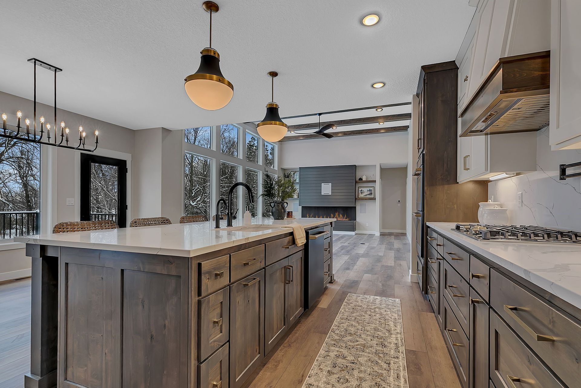 Modern kitchen with gray cabinets, large island, and fireplace.