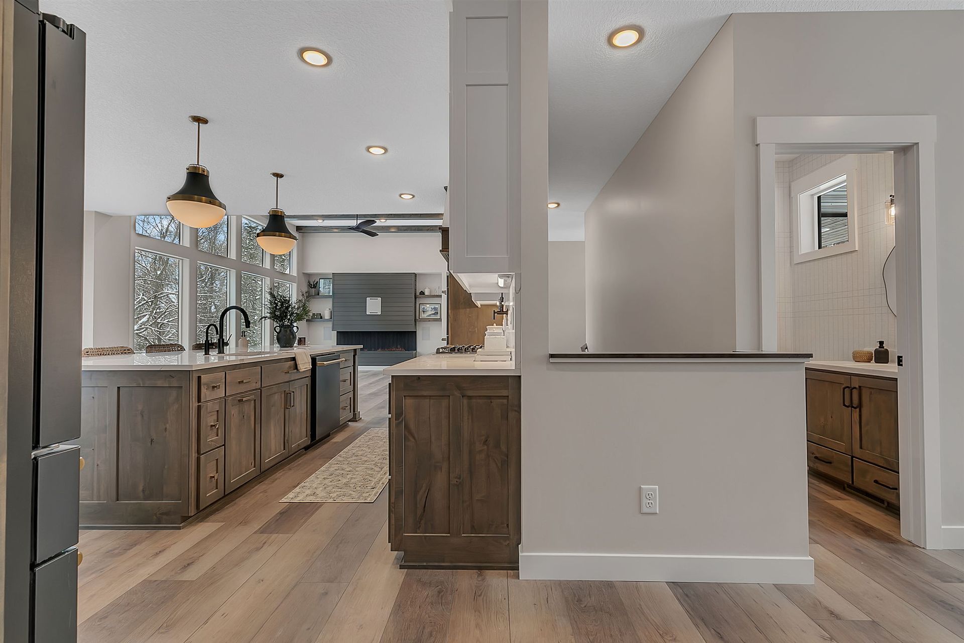 Modern kitchen with wooden cabinets, island, and dining area. Neutral color palette with natural light.