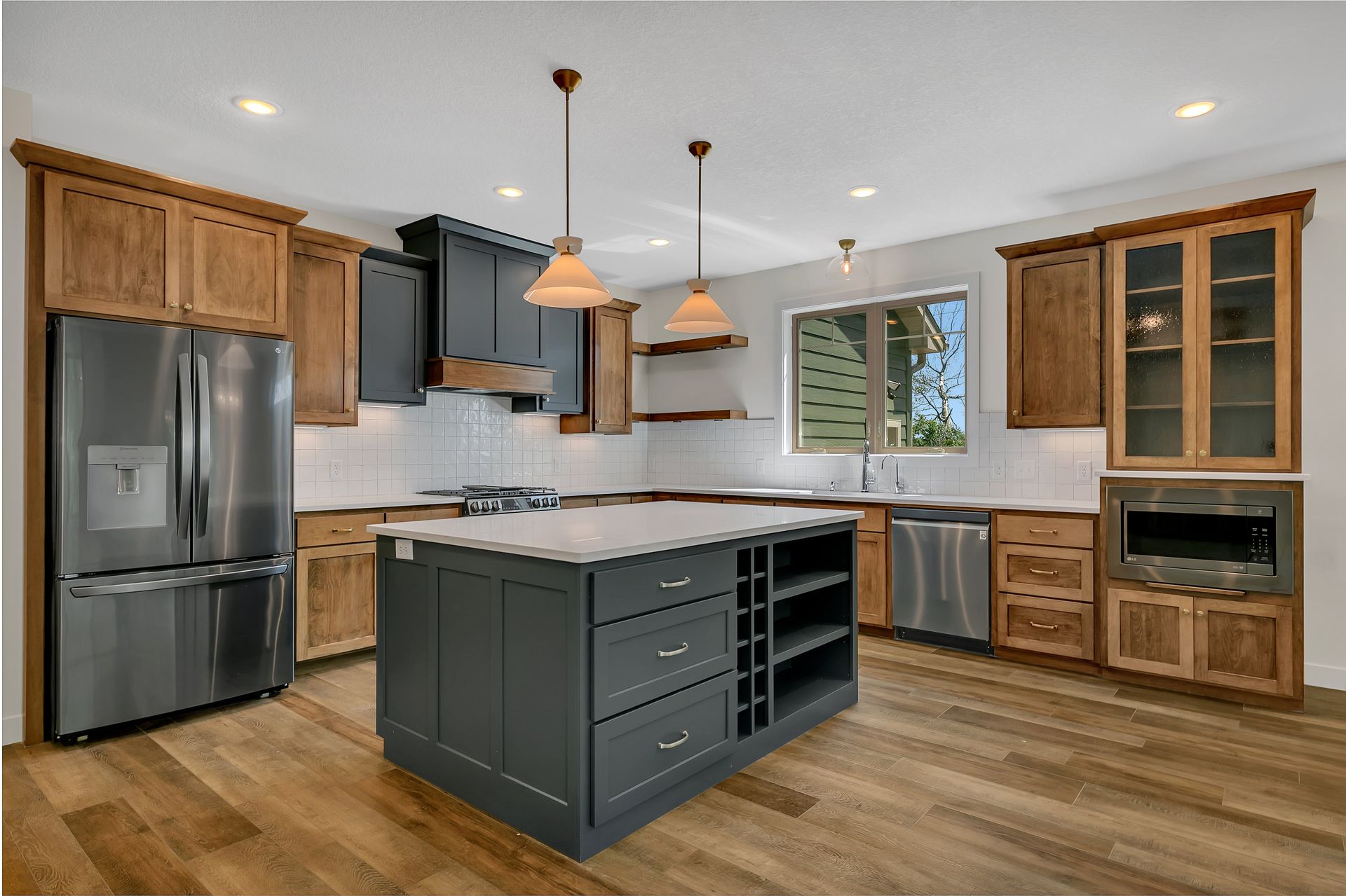 A kitchen with stainless steel appliances , wooden cabinets , and a large island.