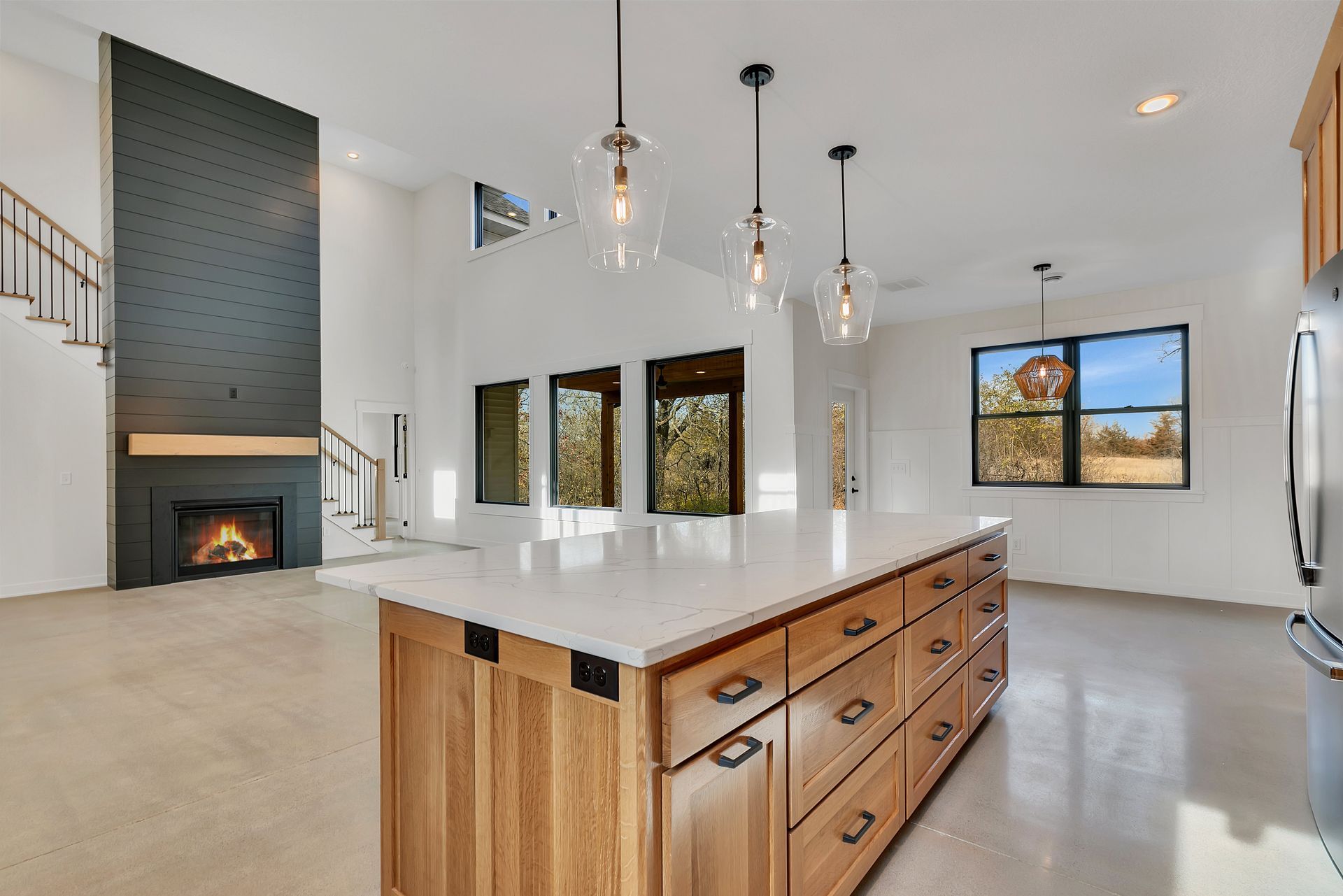 A kitchen with a large island and a fireplace.