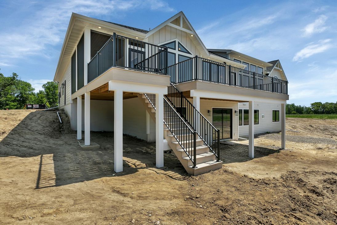 A large white house with a large deck and stairs