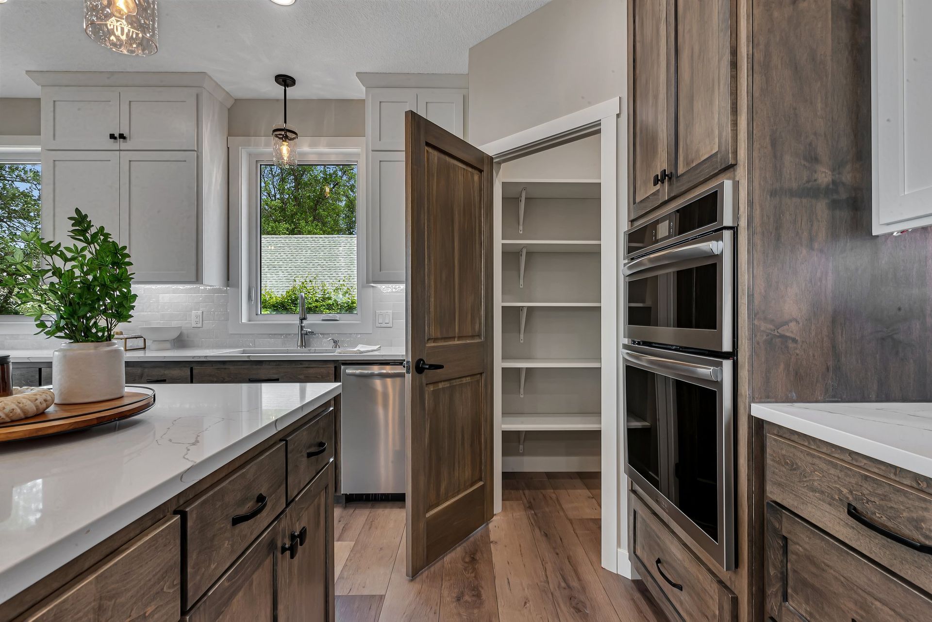 A kitchen with wooden cabinets , stainless steel appliances , and a pantry.