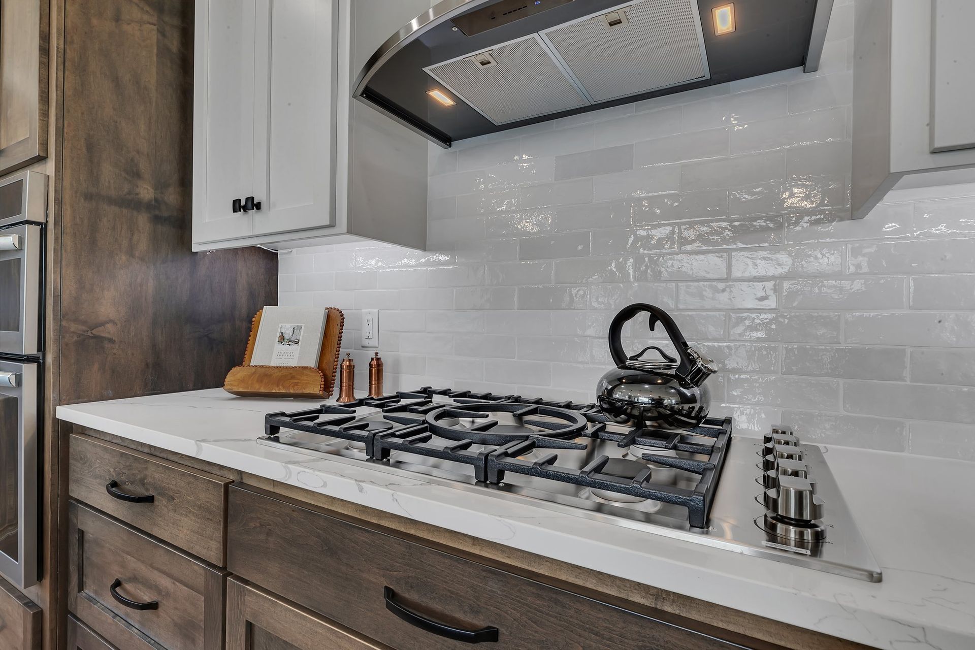 A kitchen with a stove top oven and a kettle on it.