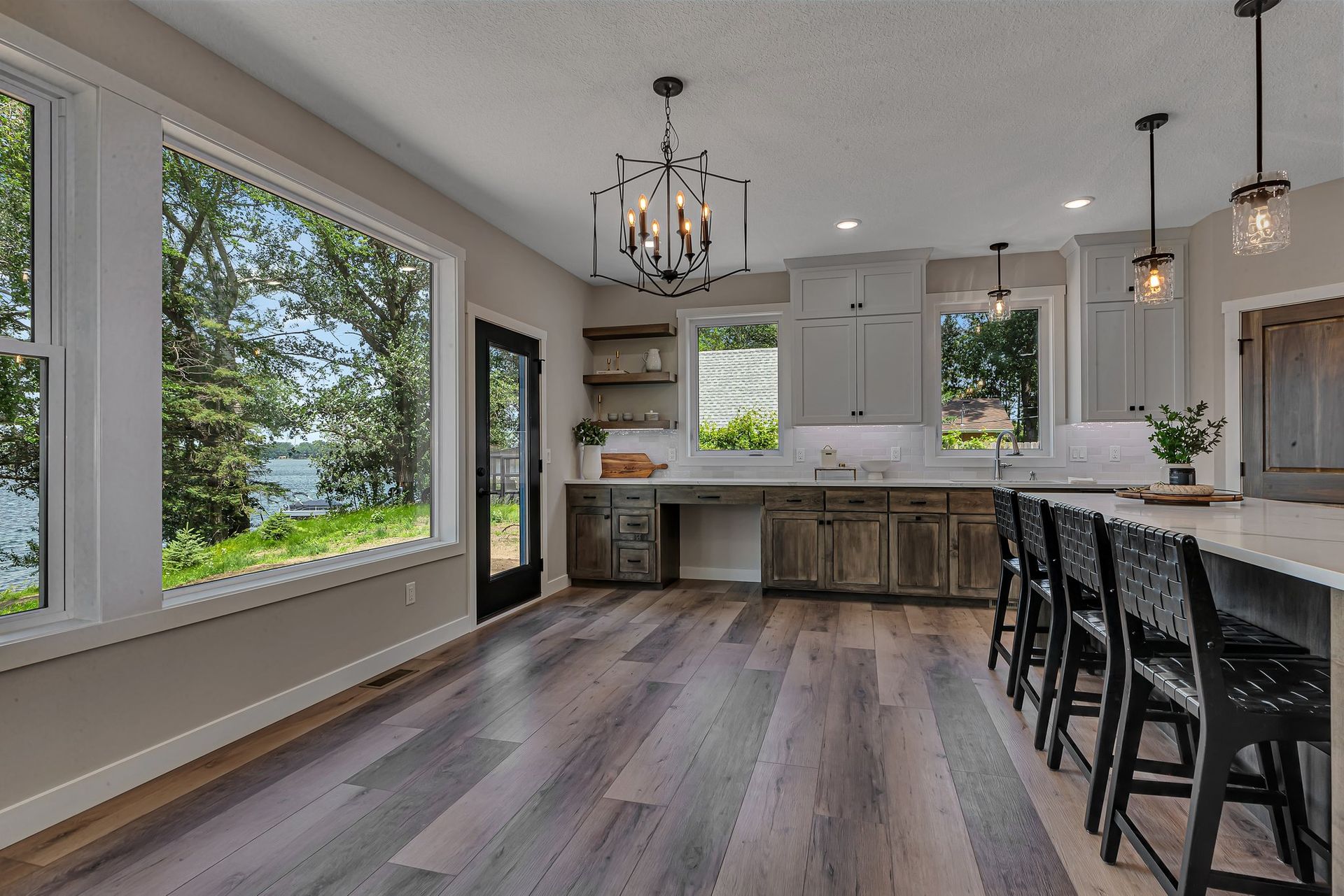 A kitchen with a lot of windows and hardwood floors