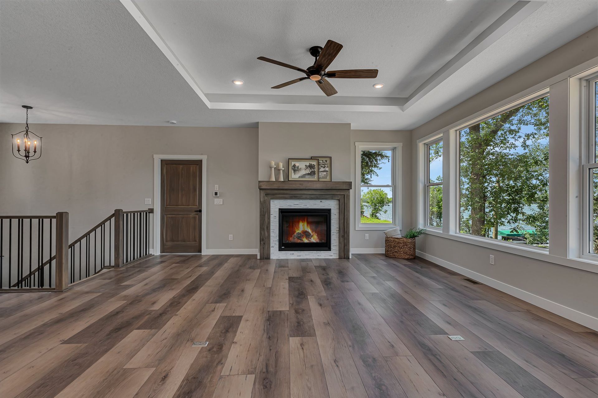 A living room with hardwood floors , a fireplace and a ceiling fan.