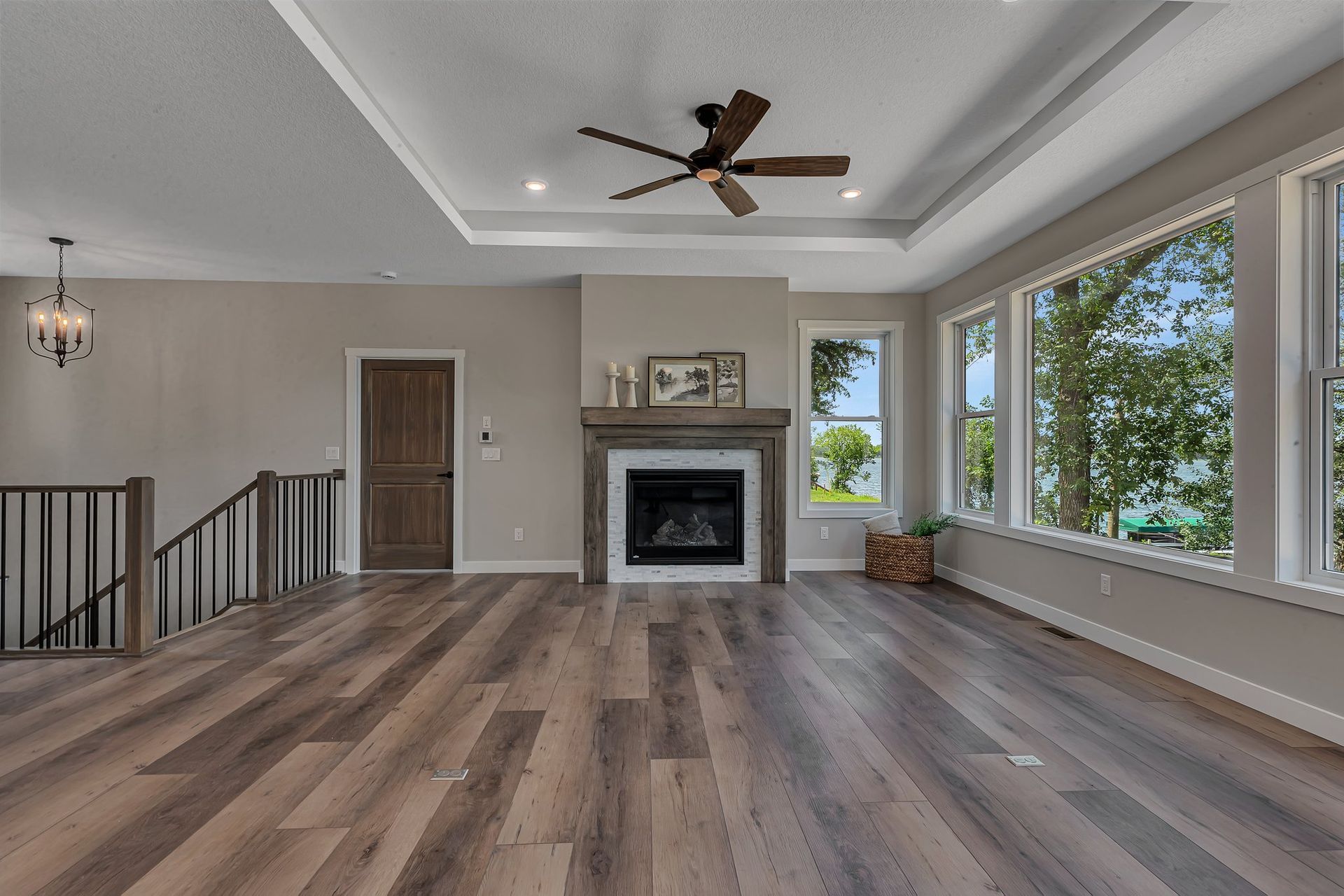 A living room with hardwood floors , a fireplace and a ceiling fan.