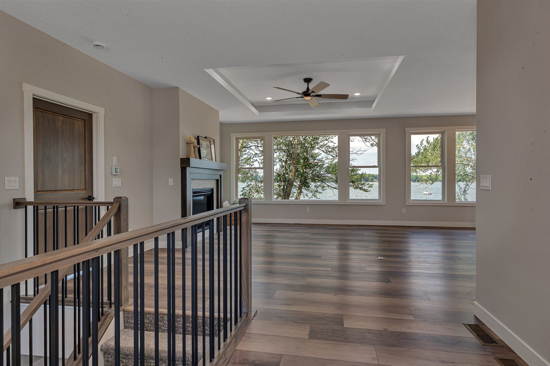 An empty living room with hardwood floors and a ceiling fan.