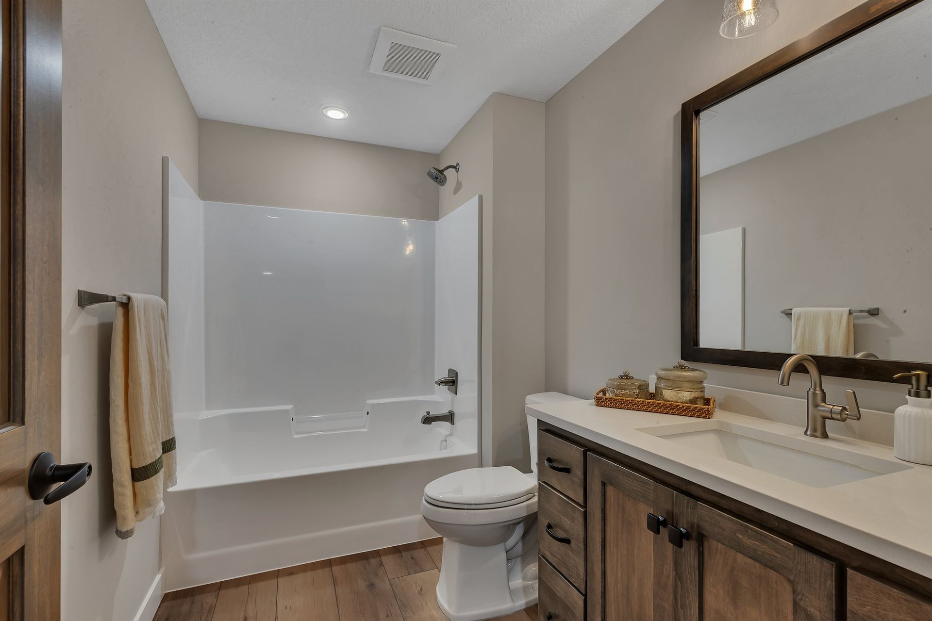 A bathroom with a toilet , sink , bathtub and mirror.