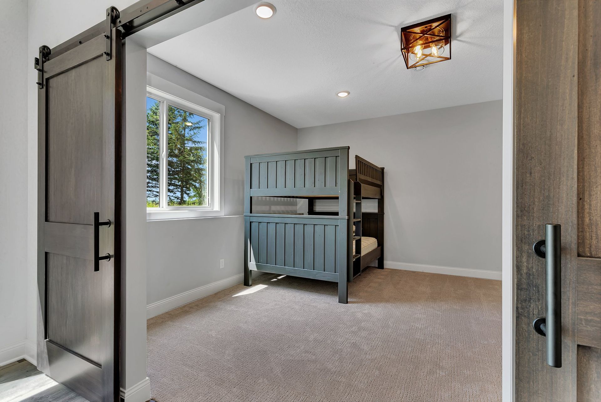A bedroom with bunk beds and a sliding barn door.