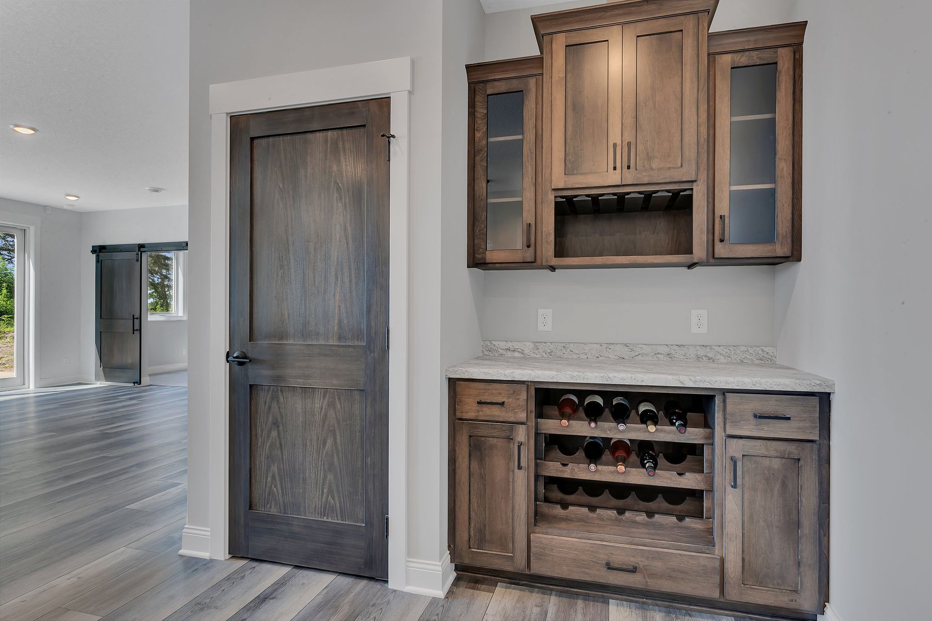 A kitchen with wooden cabinets and a wine rack.
