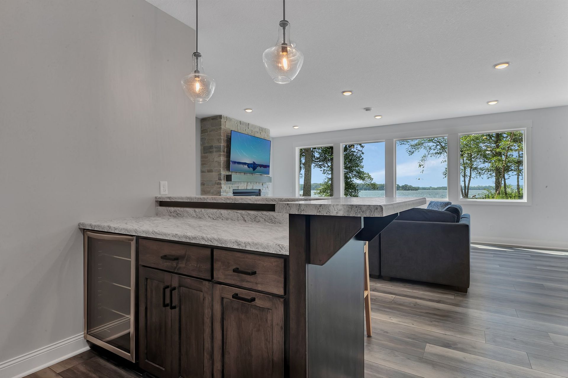 A kitchen with a bar and a refrigerator in it.