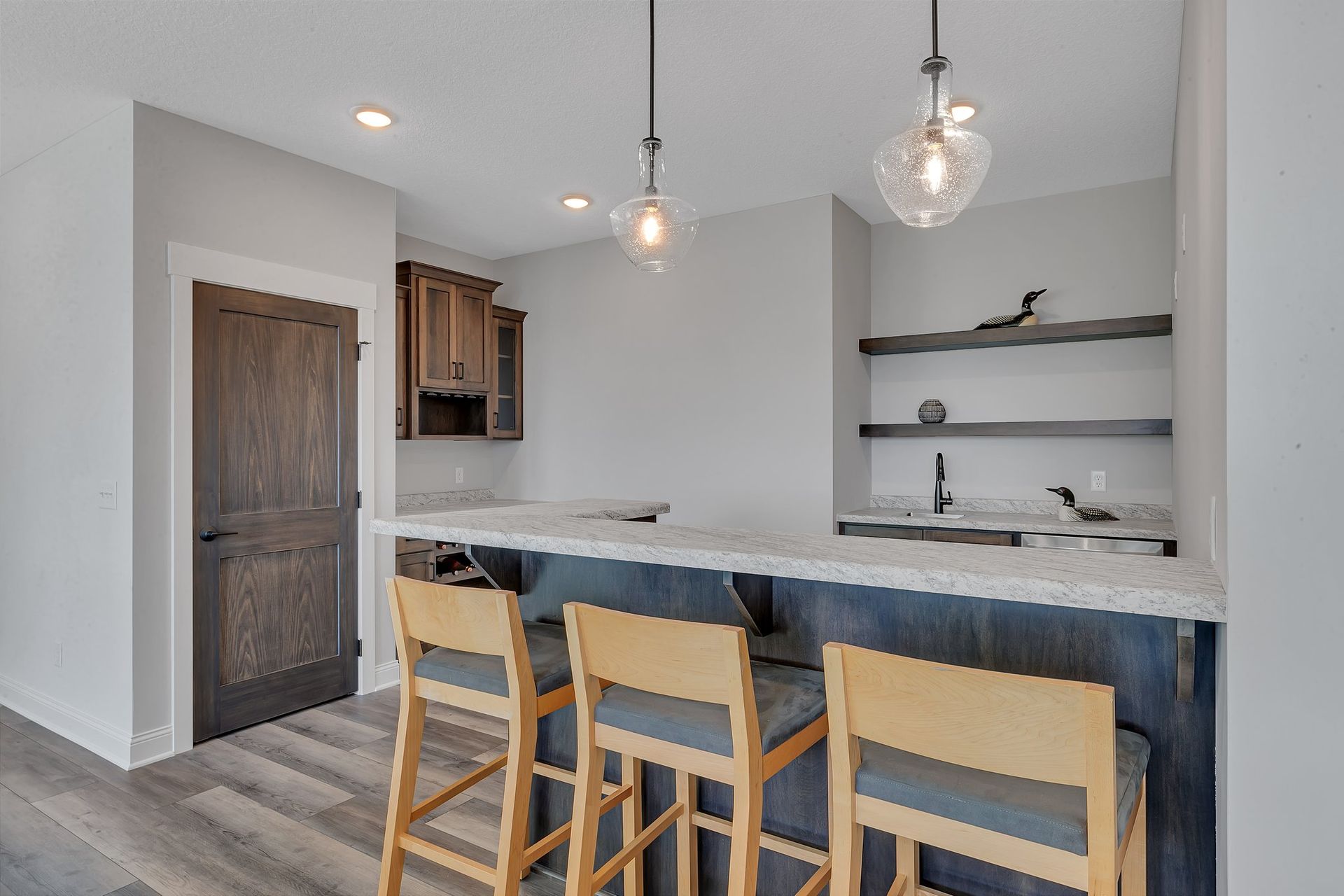 A kitchen with a bar and stools in it.