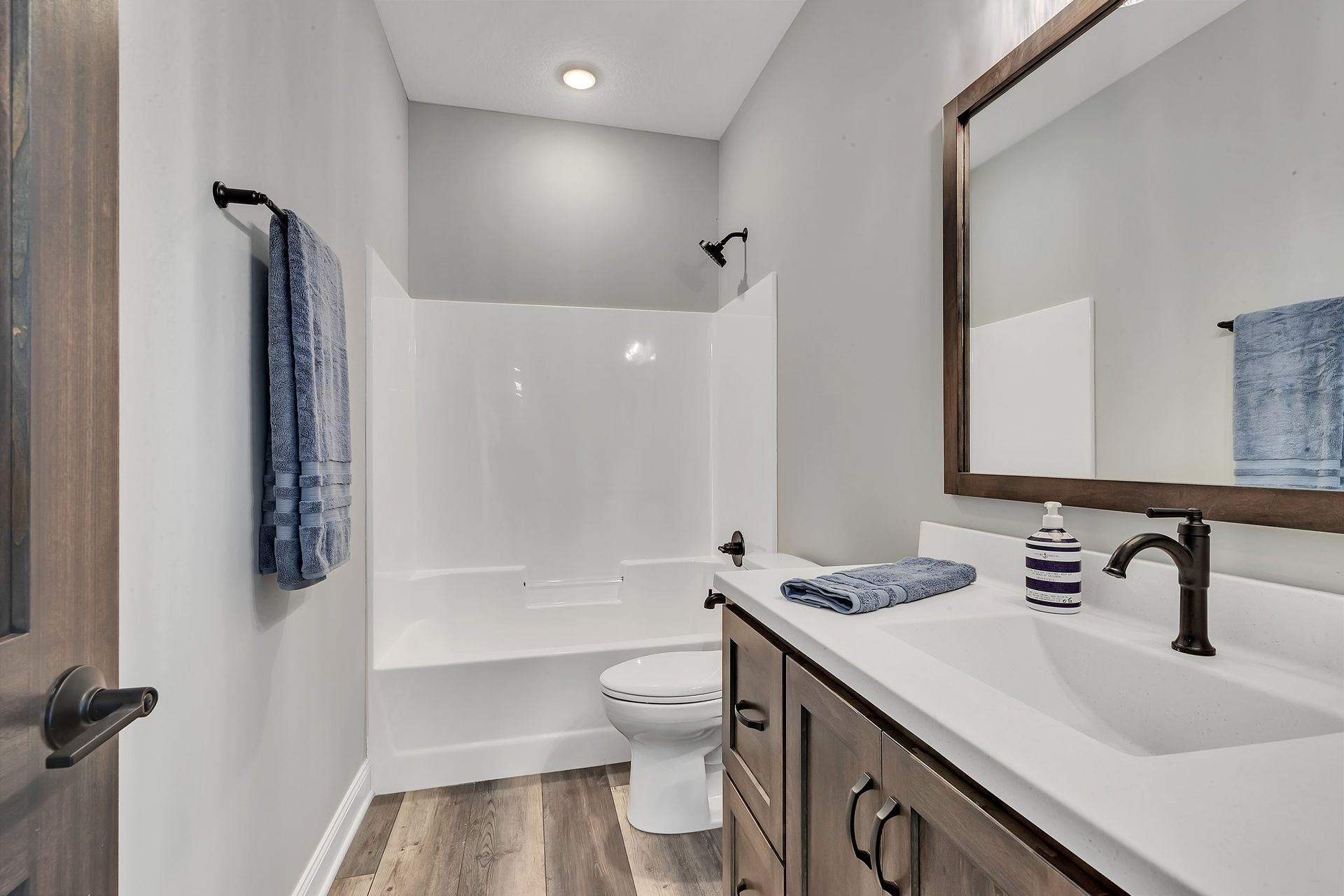 A bathroom with a sink , toilet , bathtub and mirror.