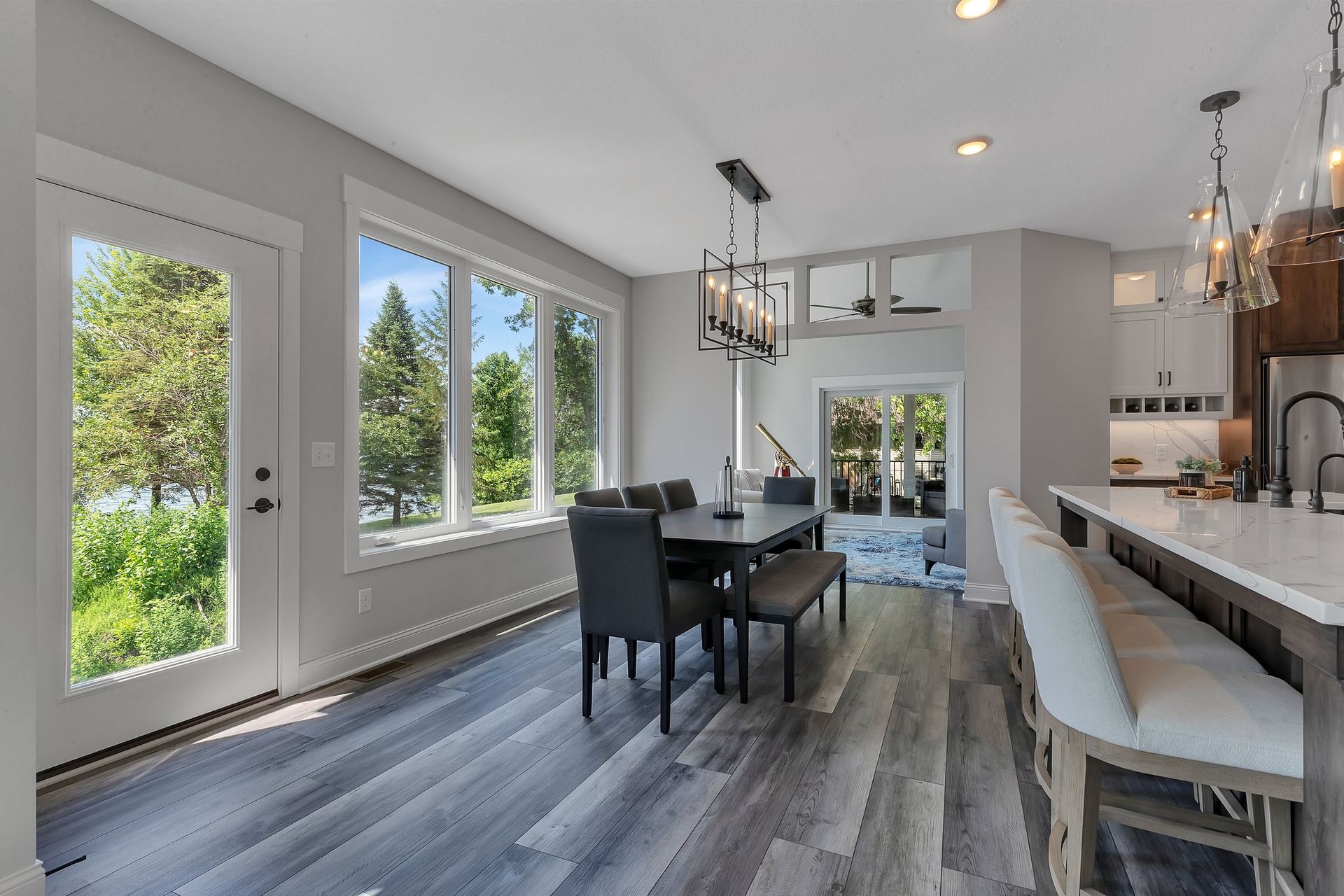 A dining room with a table and chairs and a large window.
