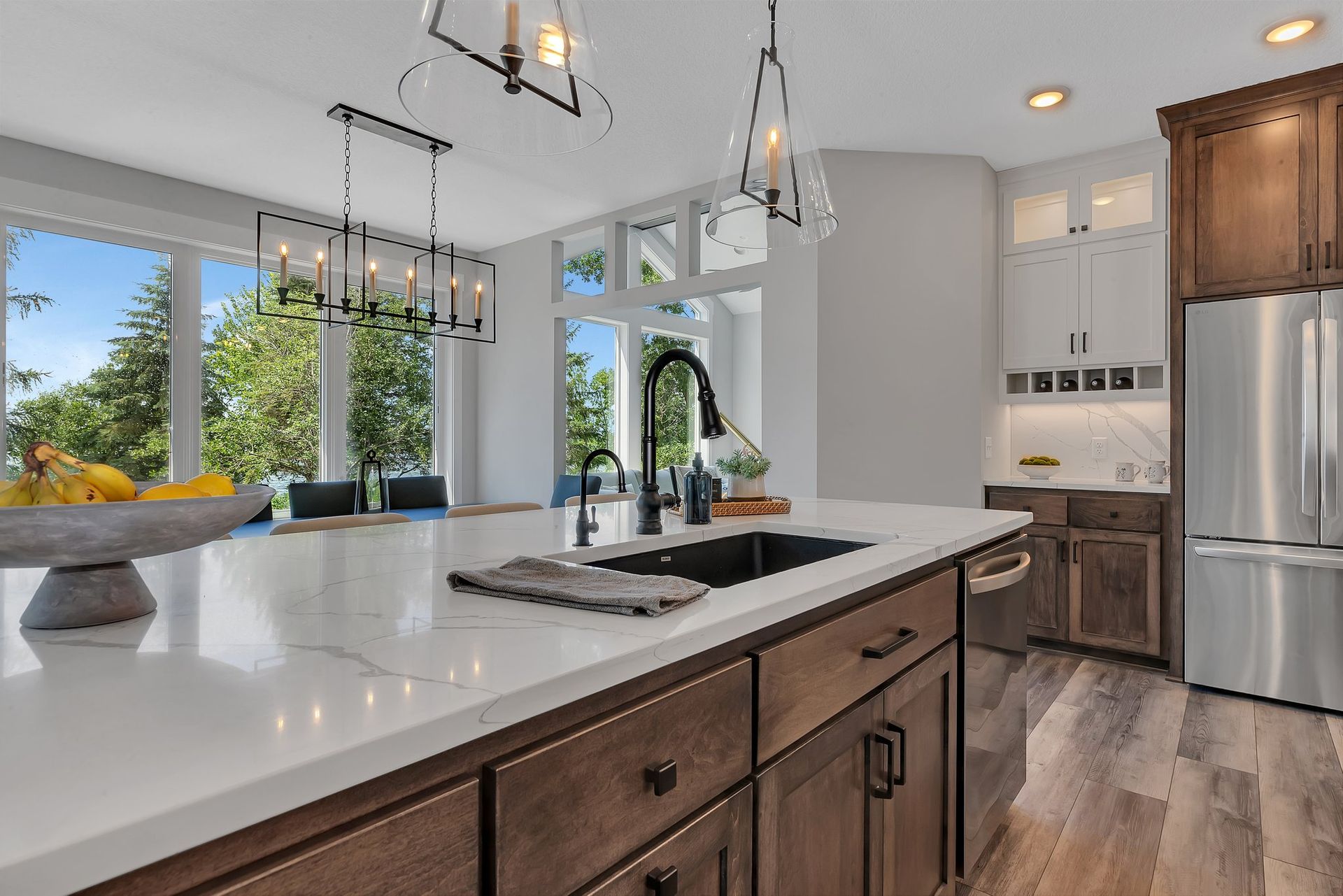 A kitchen with stainless steel appliances , wooden cabinets , a sink and a refrigerator.