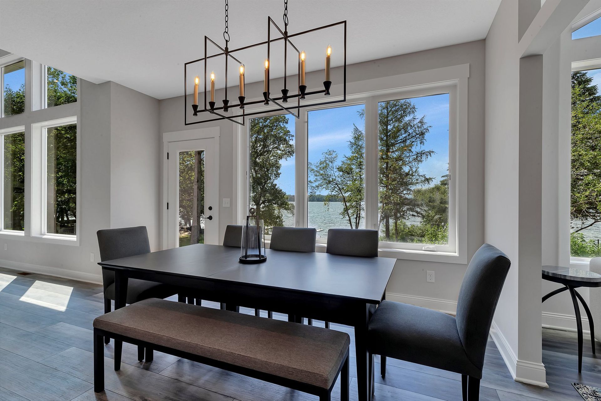 A dining room with a table and chairs and a bench.
