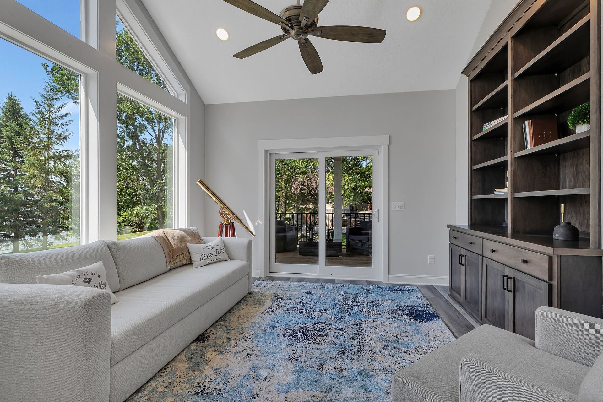 A living room with a couch and chairs and a ceiling fan
