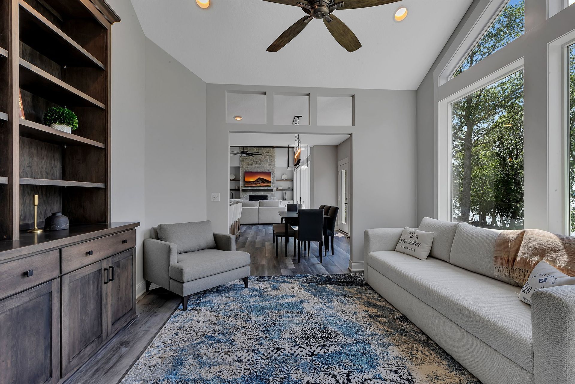 A living room with a couch and chairs and a ceiling fan