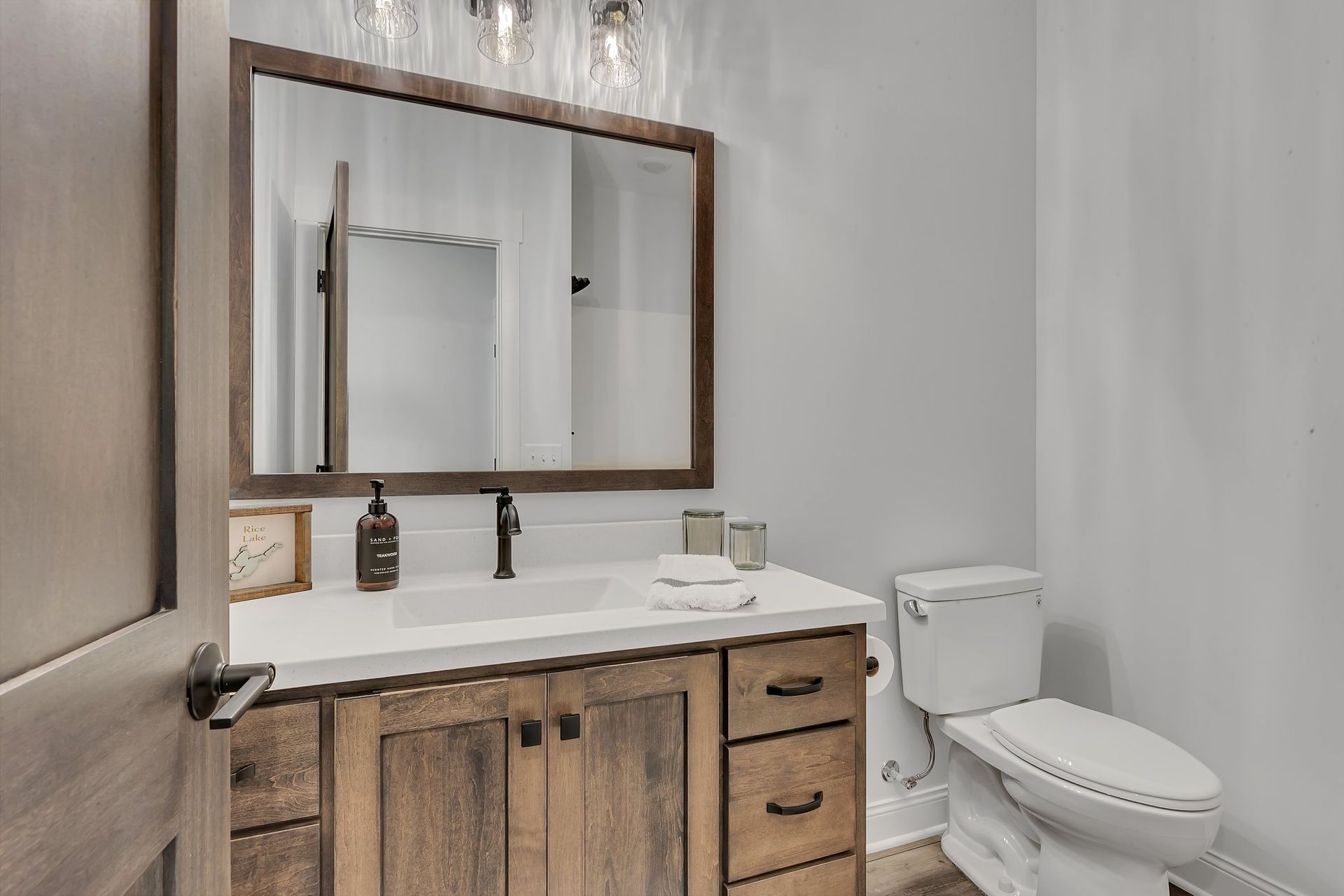A bathroom with a sink , toilet and mirror.
