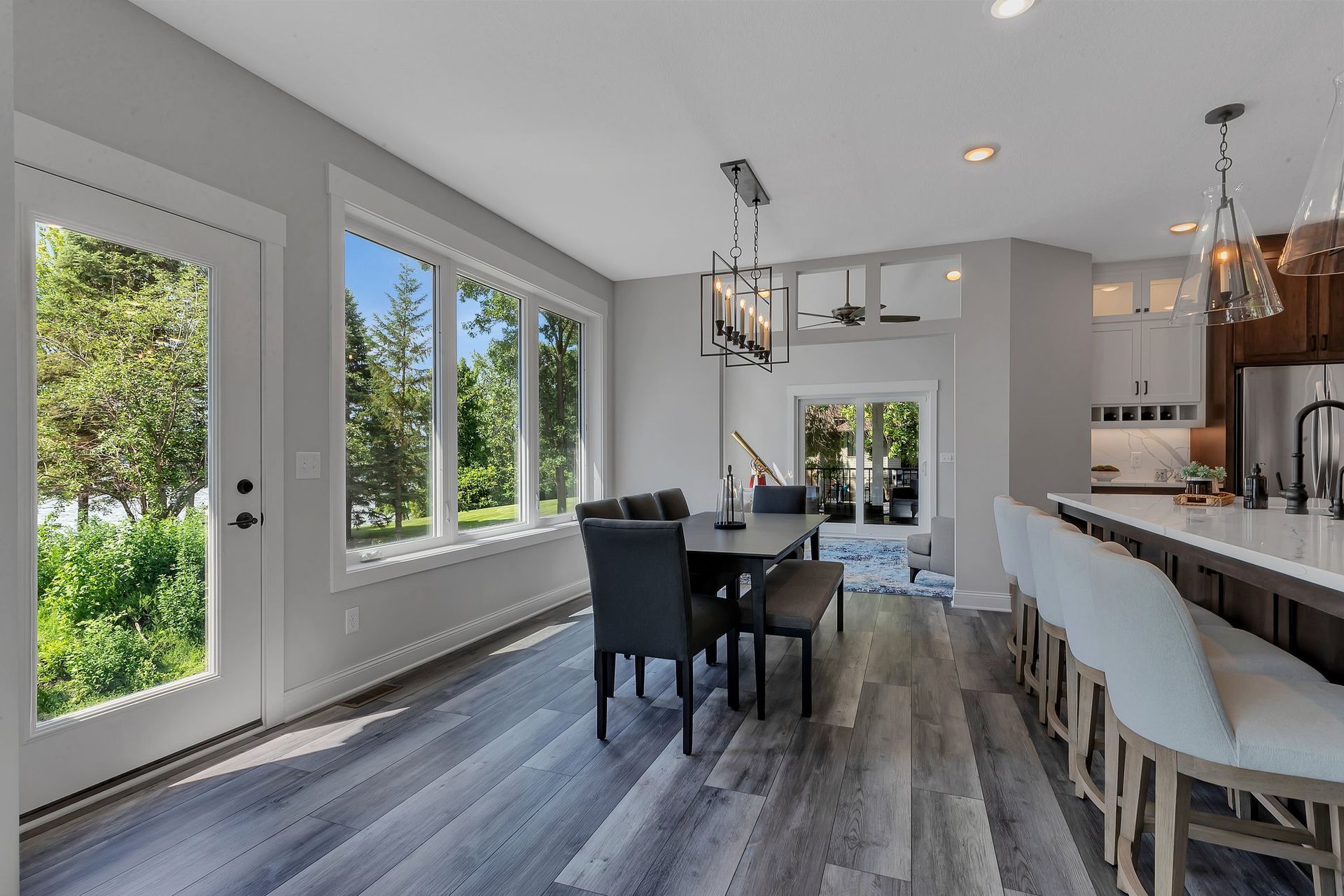 A dining room with a table and chairs and a large window.