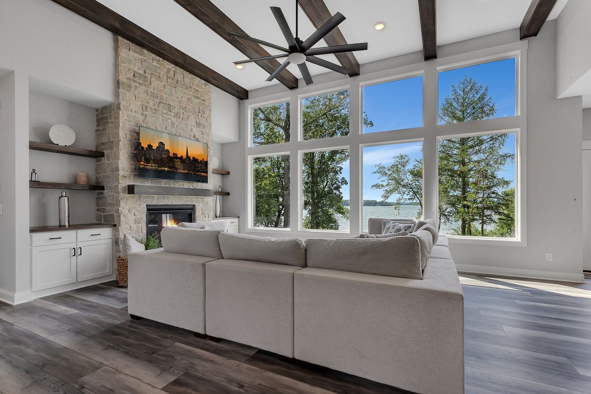 A living room with a couch , fireplace , and lots of windows.