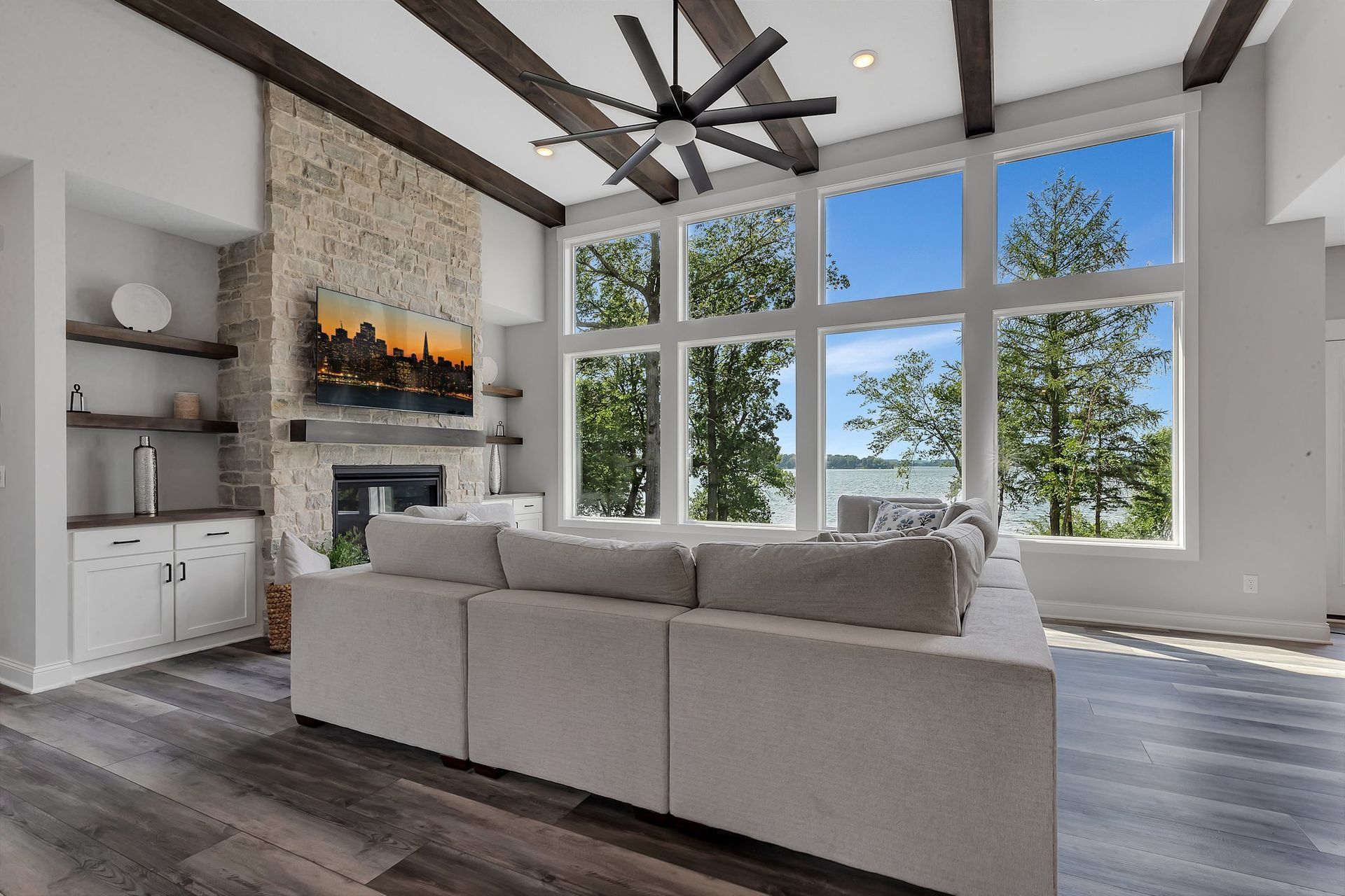 A living room with a couch , fireplace , and lots of windows.