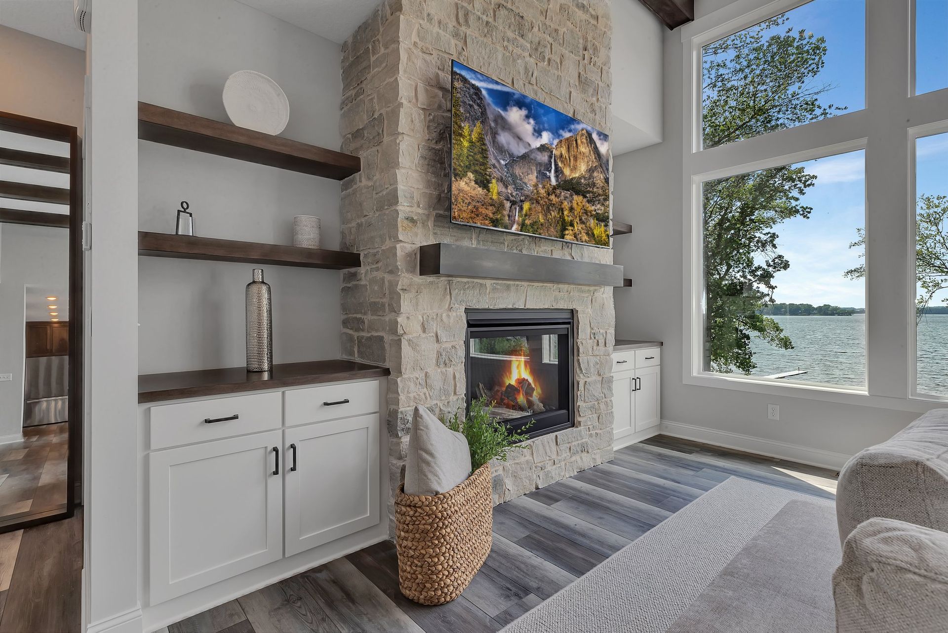 A living room with a fireplace and a flat screen tv on the wall.