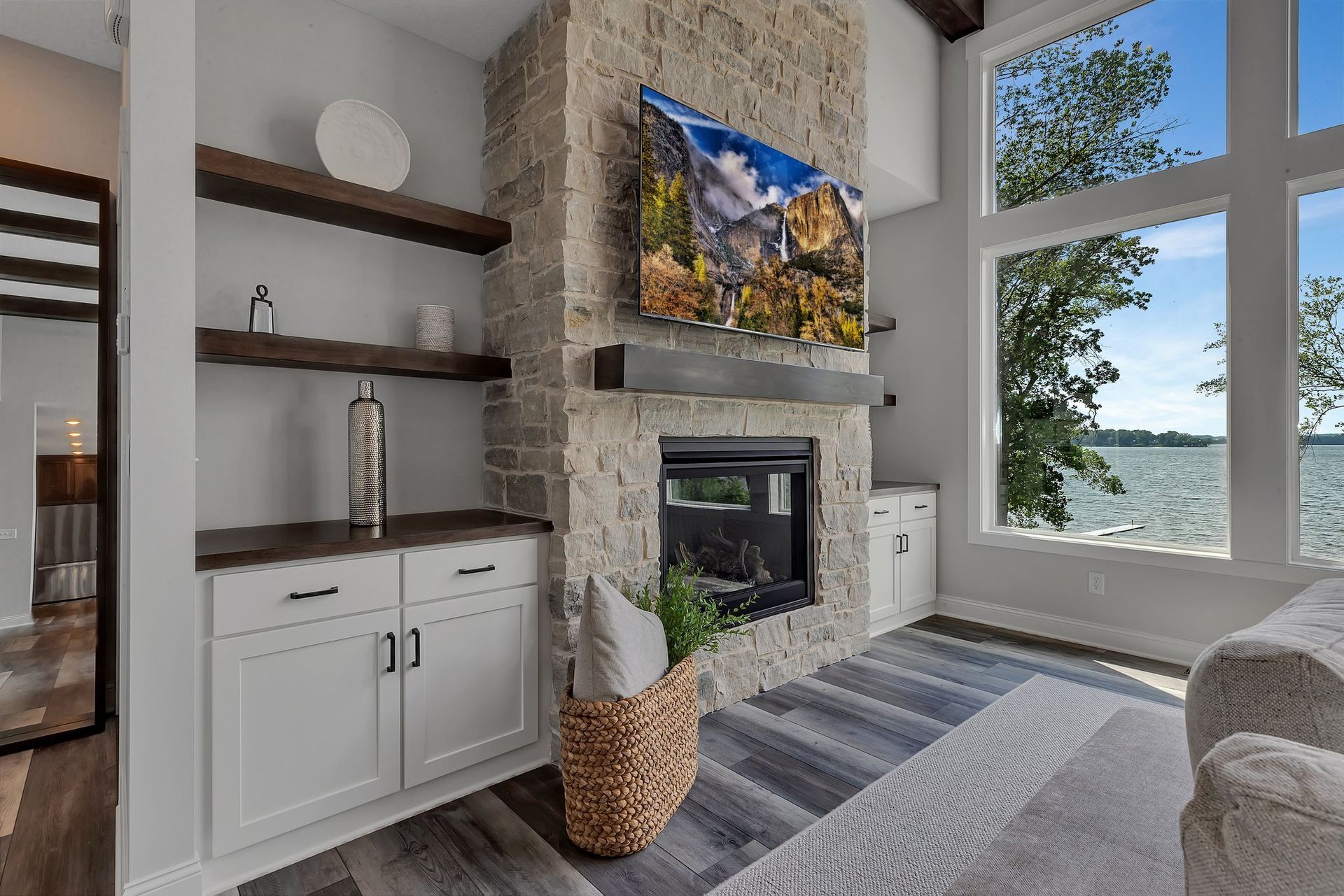 A living room with a fireplace and a flat screen tv on the wall.