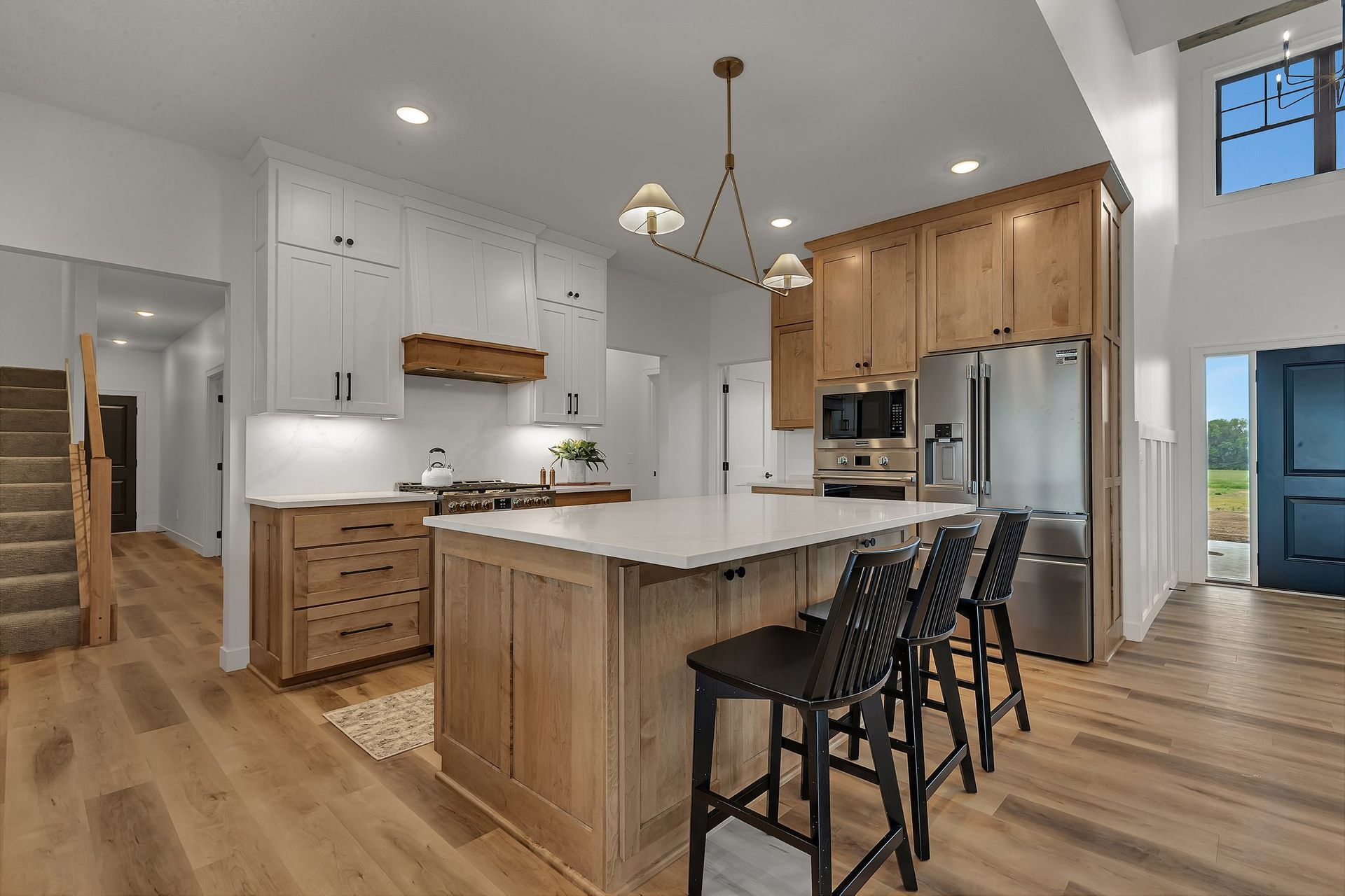 A kitchen with wooden cabinets , stainless steel appliances , and a large island.