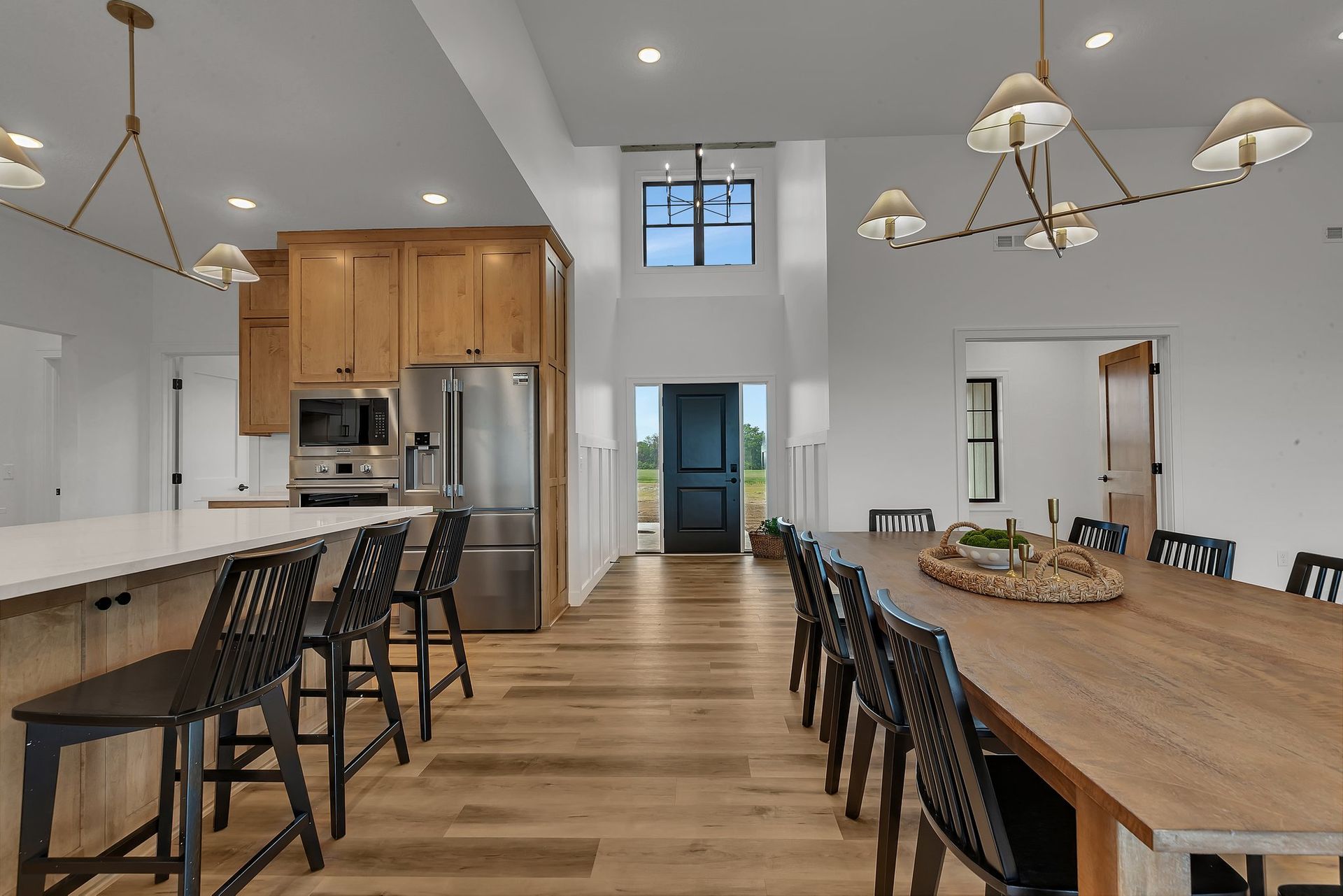 A kitchen and dining room in a house with a long wooden table and chairs.