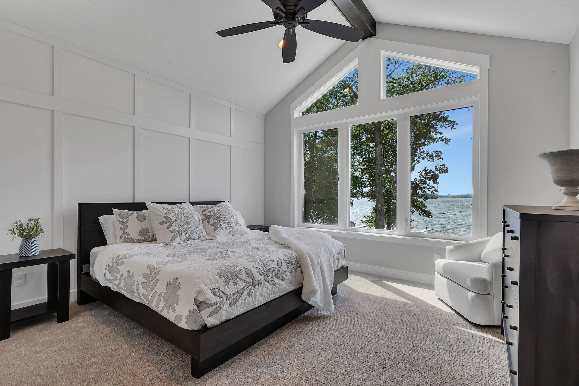 A bedroom with a large bed and a ceiling fan.