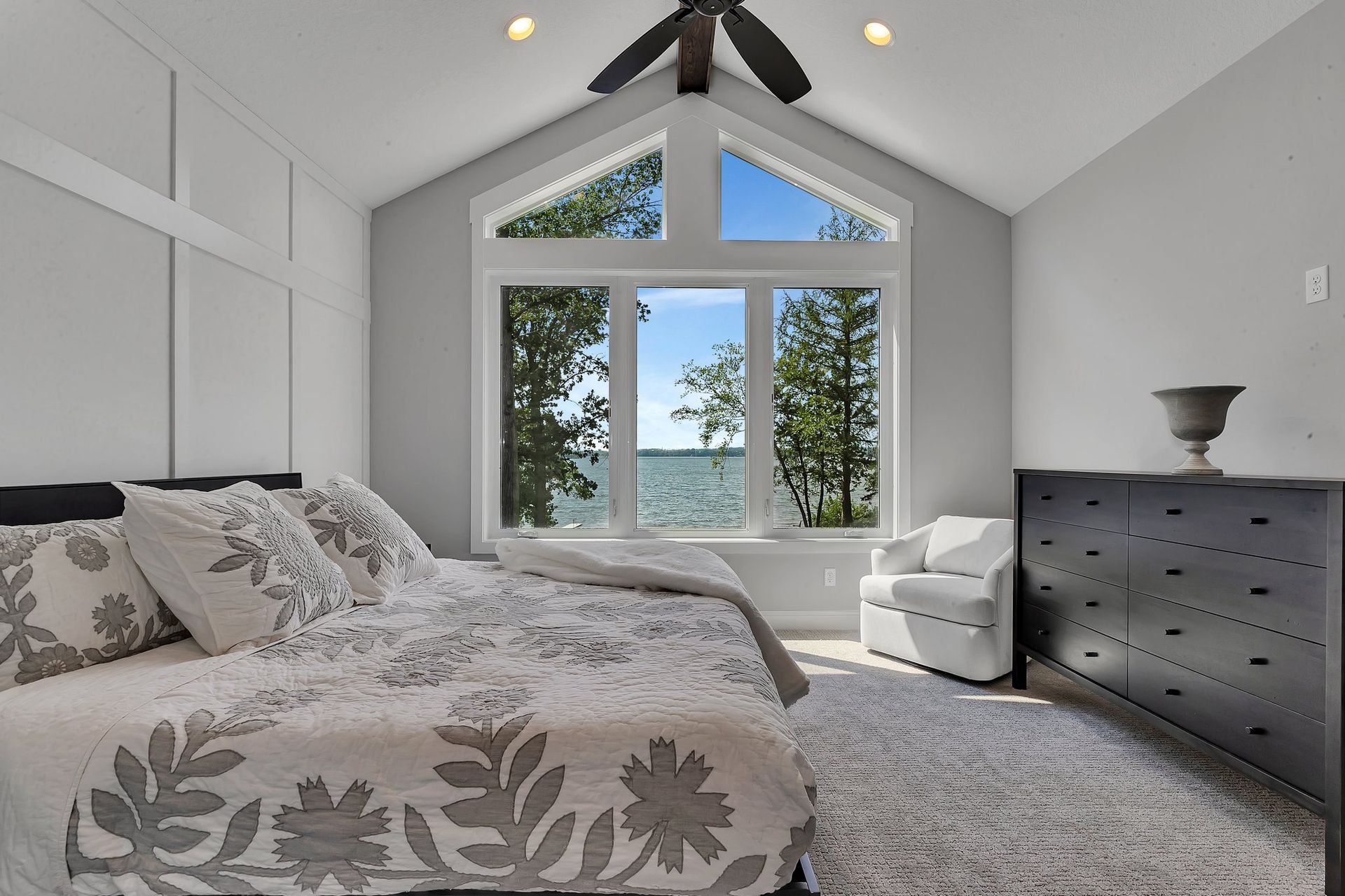 A bedroom with a large bed and a ceiling fan