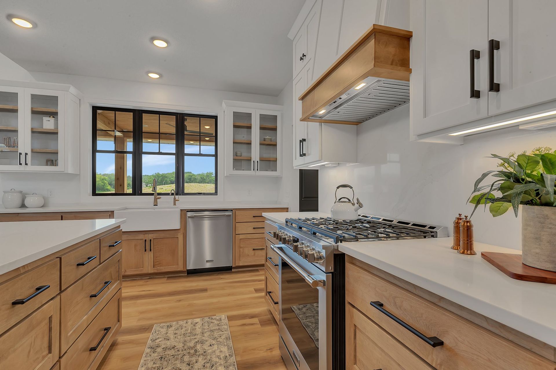 A kitchen with wooden cabinets , stainless steel appliances , a stove , and a sink.