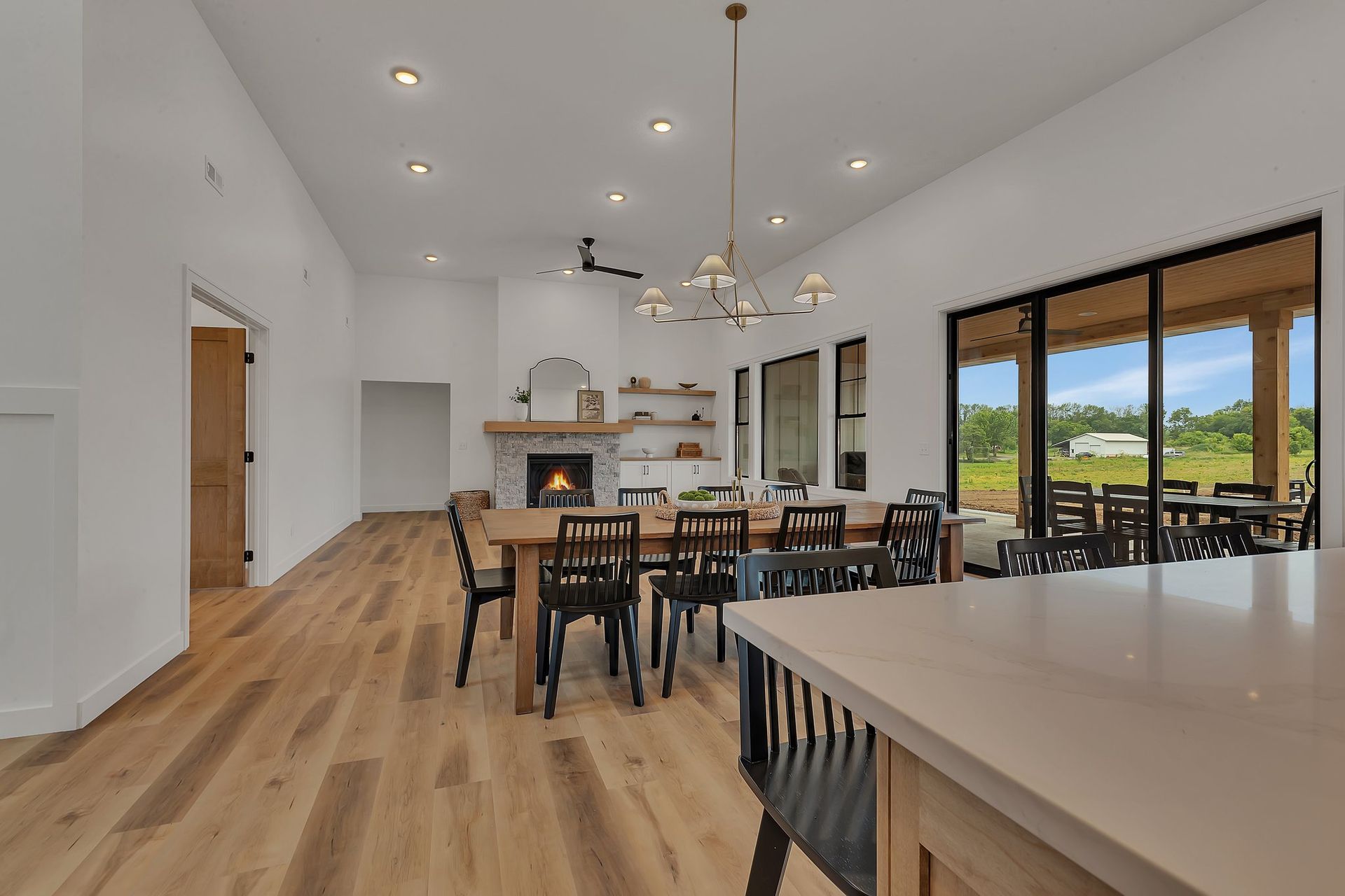 A large dining room with a table and chairs and a fireplace.