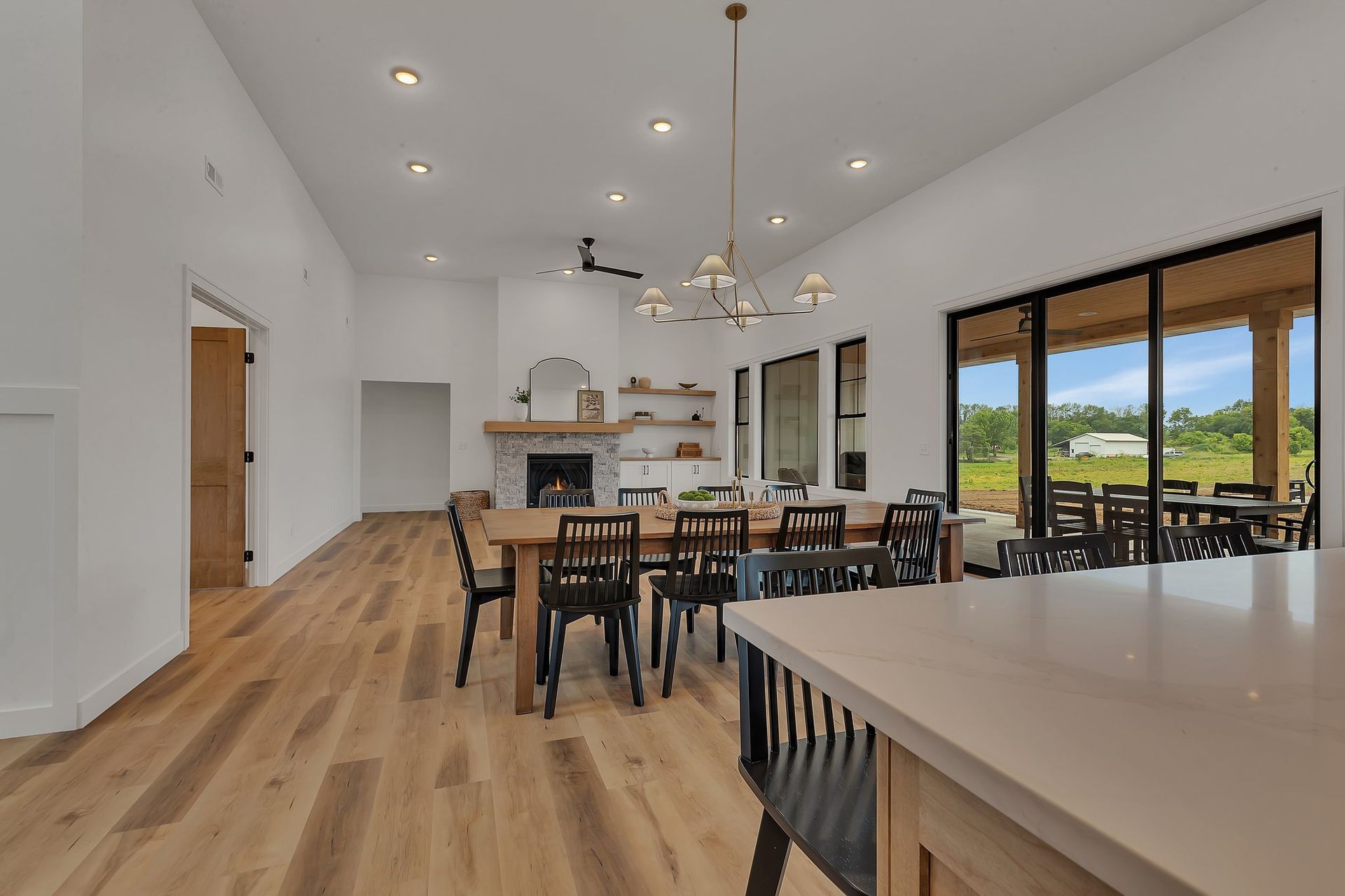 A large dining room with a table and chairs and a fireplace.