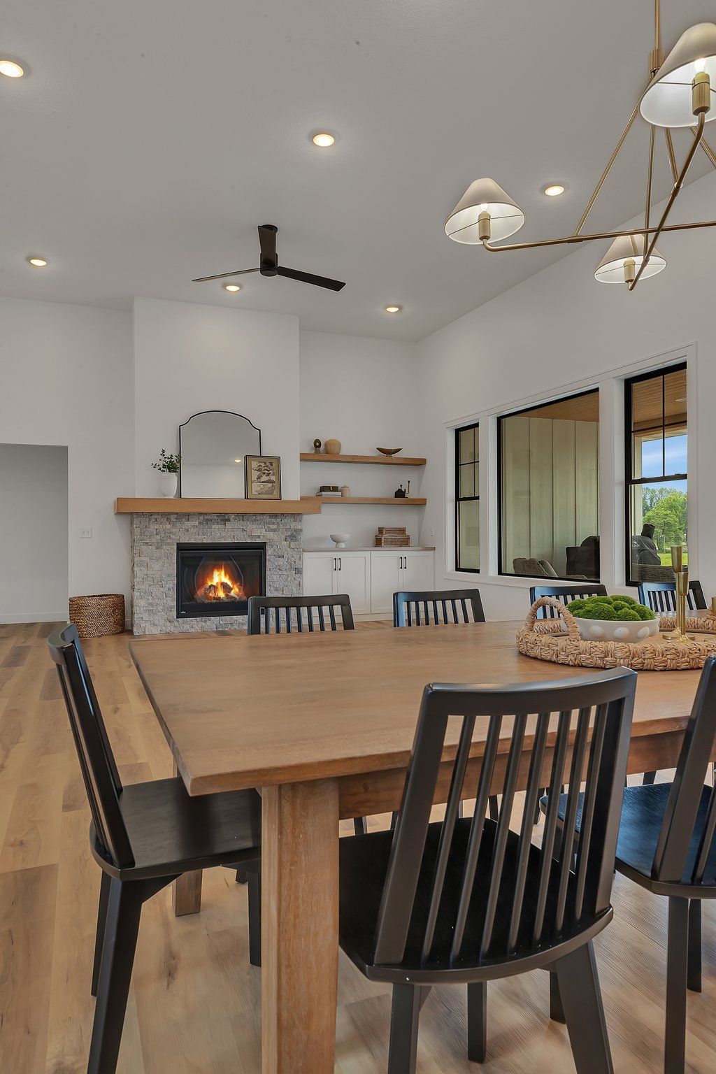 A dining room with a table and chairs and a fireplace.