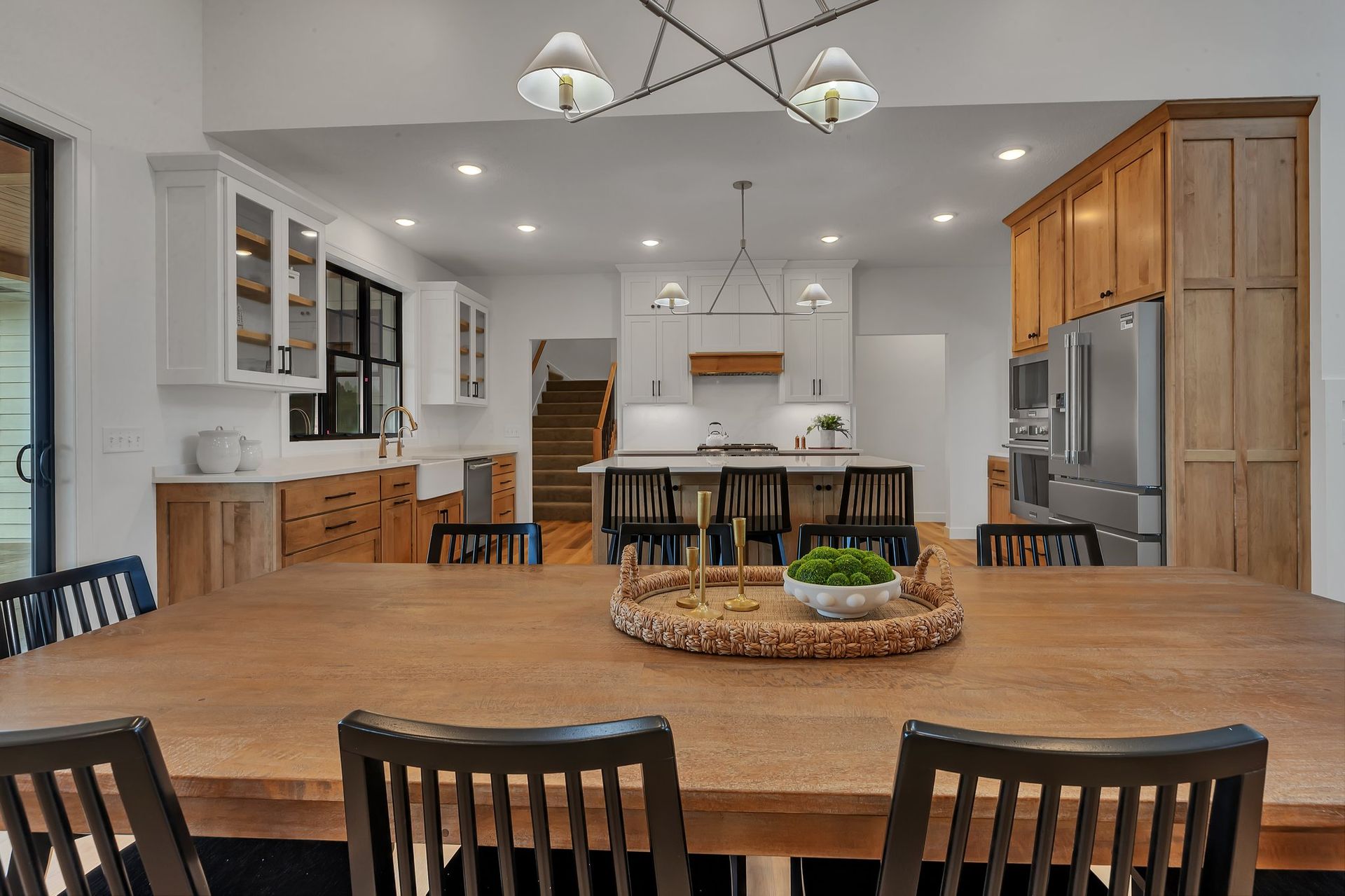 A kitchen and dining room with a large wooden table and chairs.