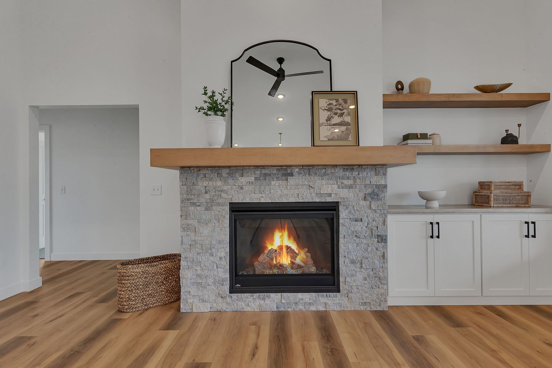 A living room with a fireplace and a ceiling fan