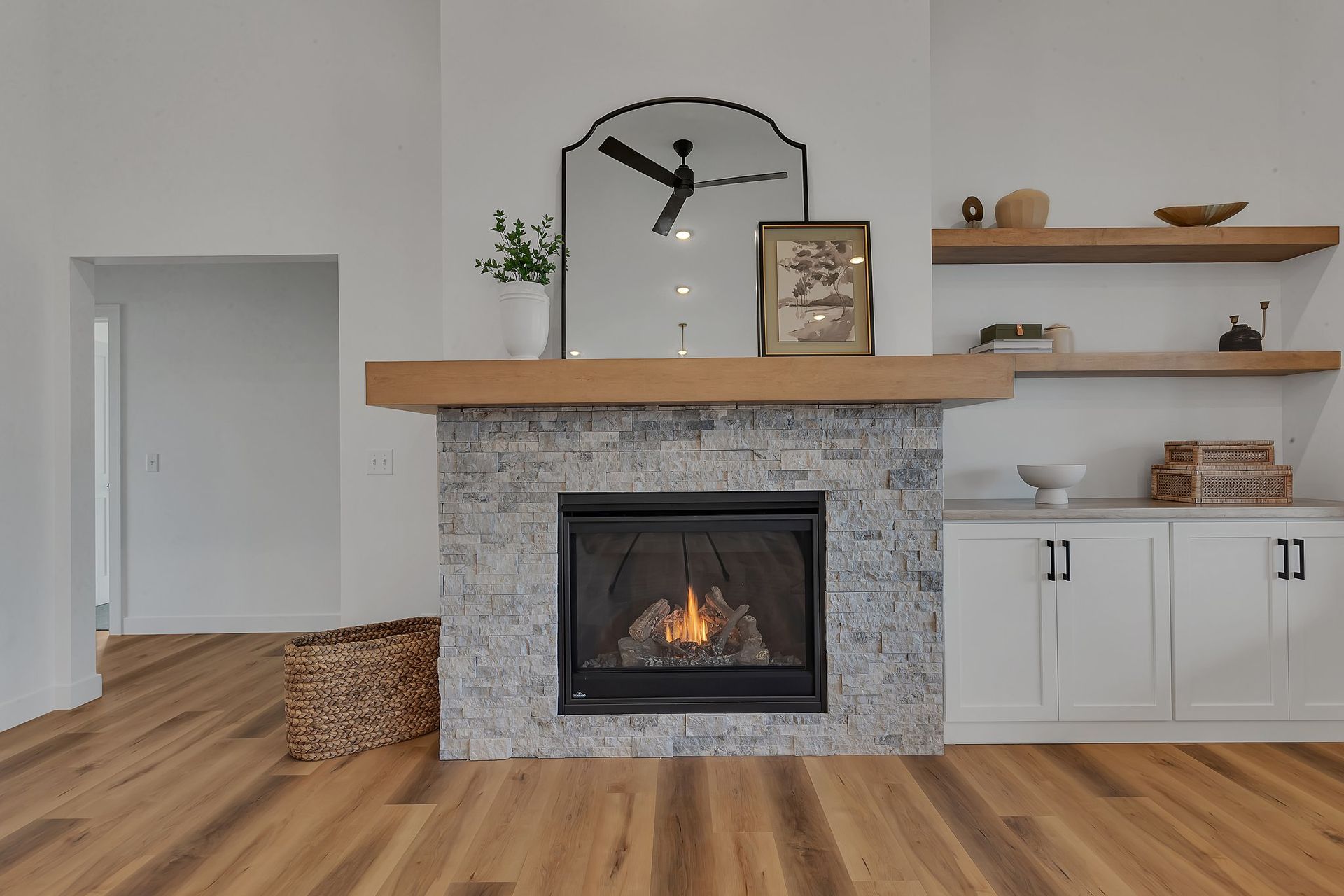 A living room with a fireplace and a ceiling fan