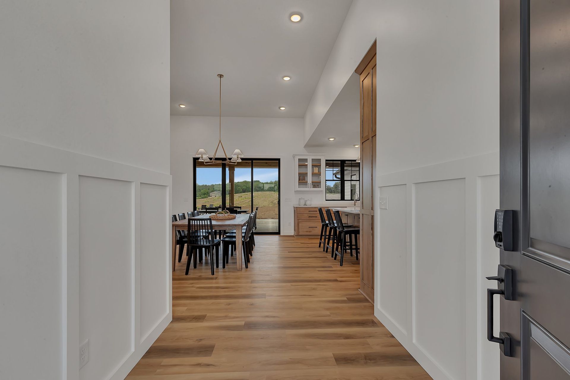 A hallway in a house leading to a dining room and kitchen.