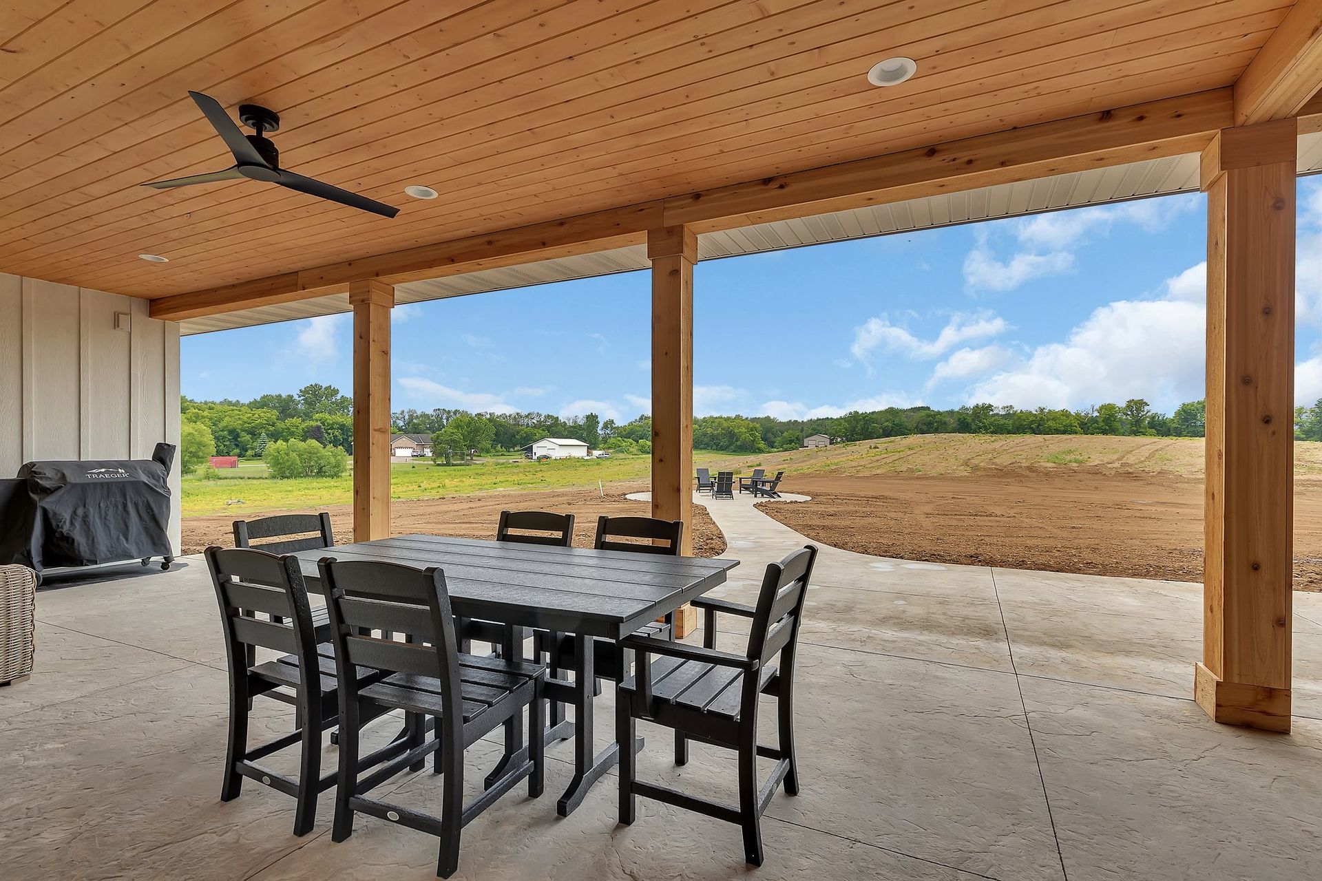 A patio with a table and chairs and a ceiling fan.