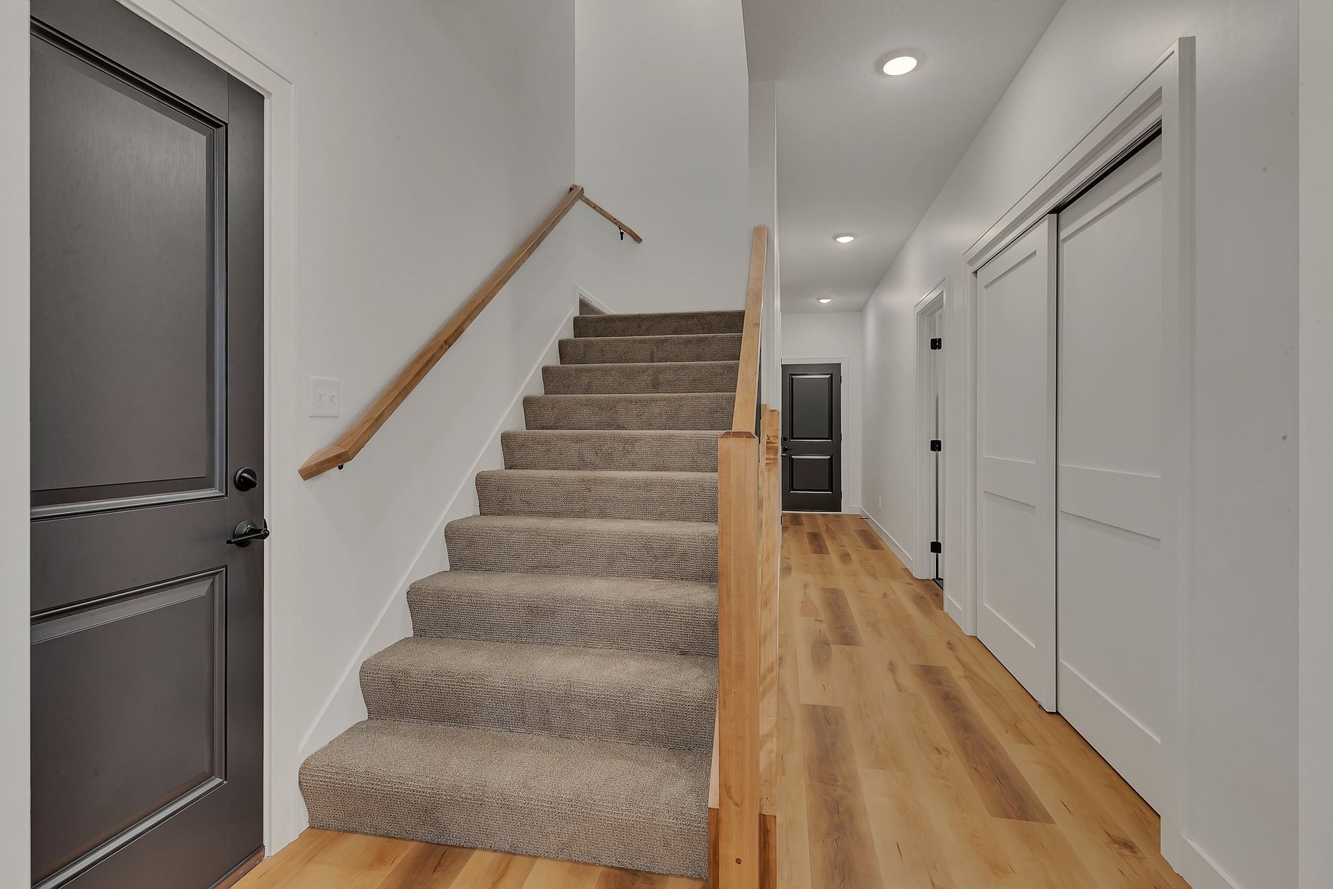 A hallway with stairs leading up to the second floor of a house.